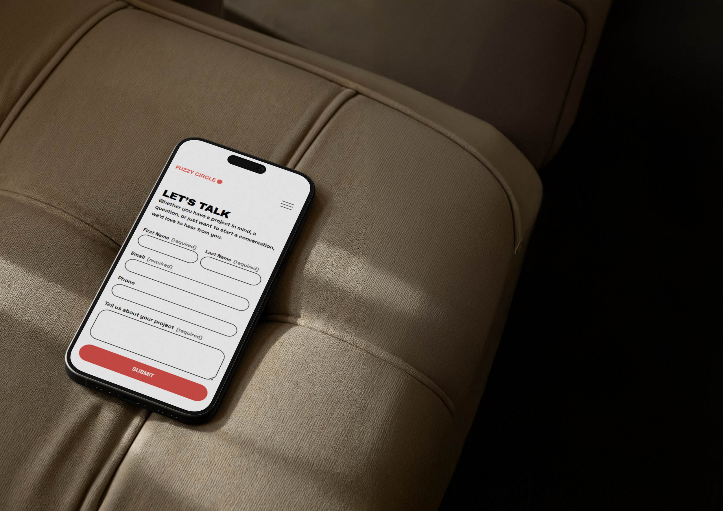 Smartphone displaying a contact form app called 'Let's Talk' on a beige cushioned surface.