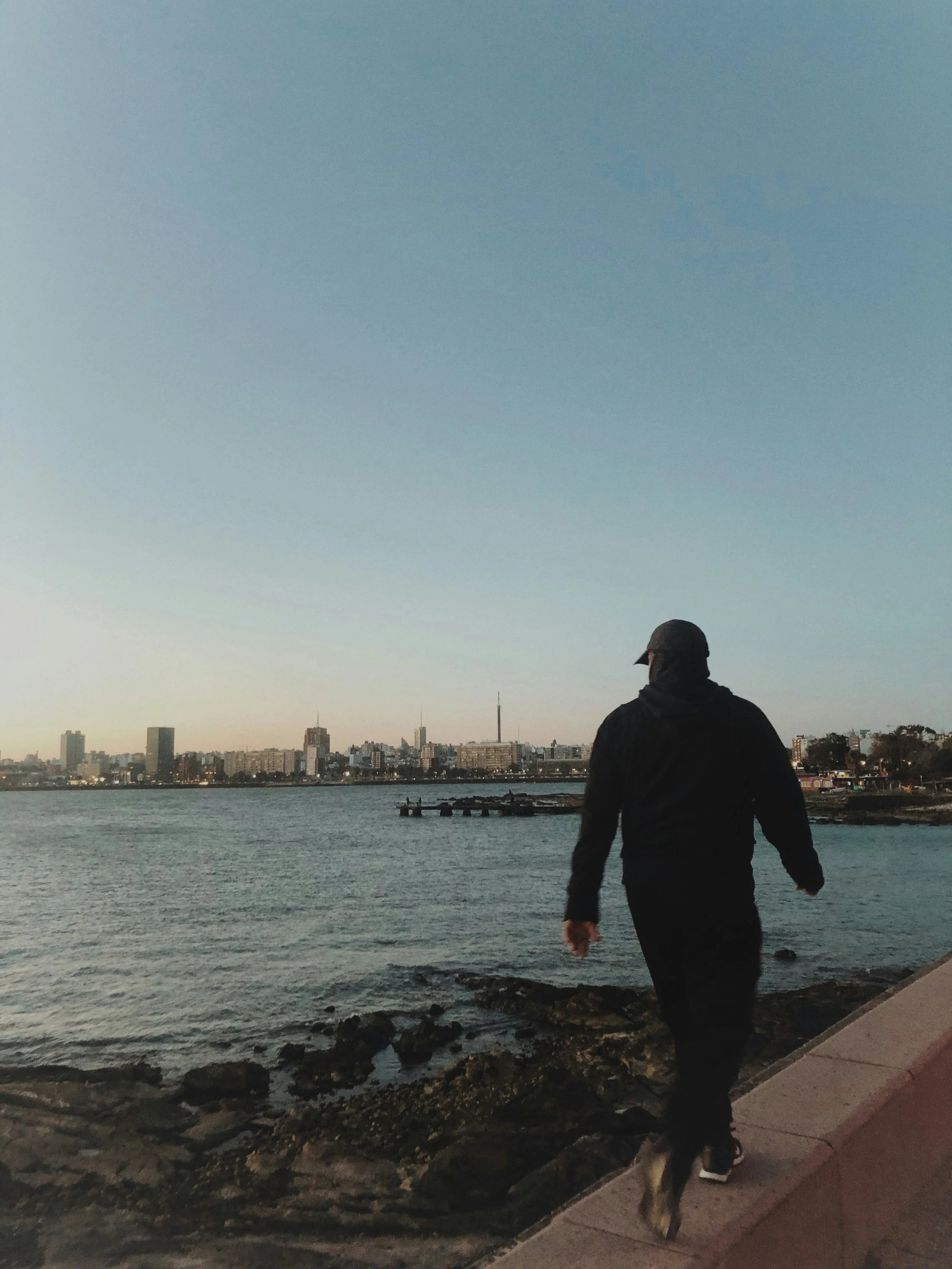 Personne marchant seule au bord de la mer, illustration de l'effet positif de la marche comme en  consultation walk and talk en psychologie.