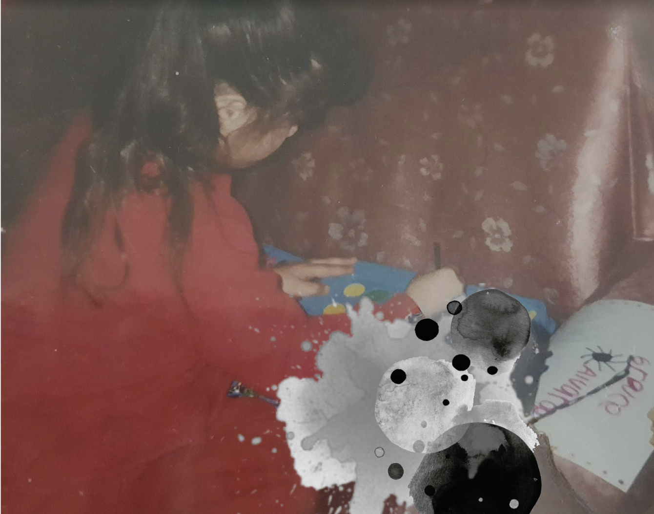 A girl with long dark hair wearing a red shirt, sitting on the floor, reading a colorful book with a blue cover.