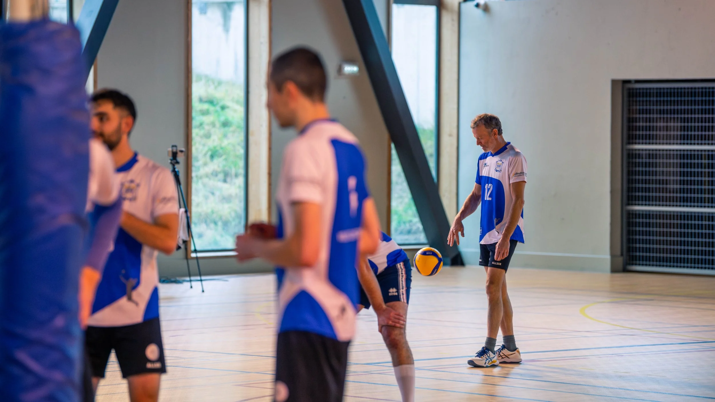 Entraîneur de volley-ball et joueurs pendant une séance d'entraînement dans une salle de sport