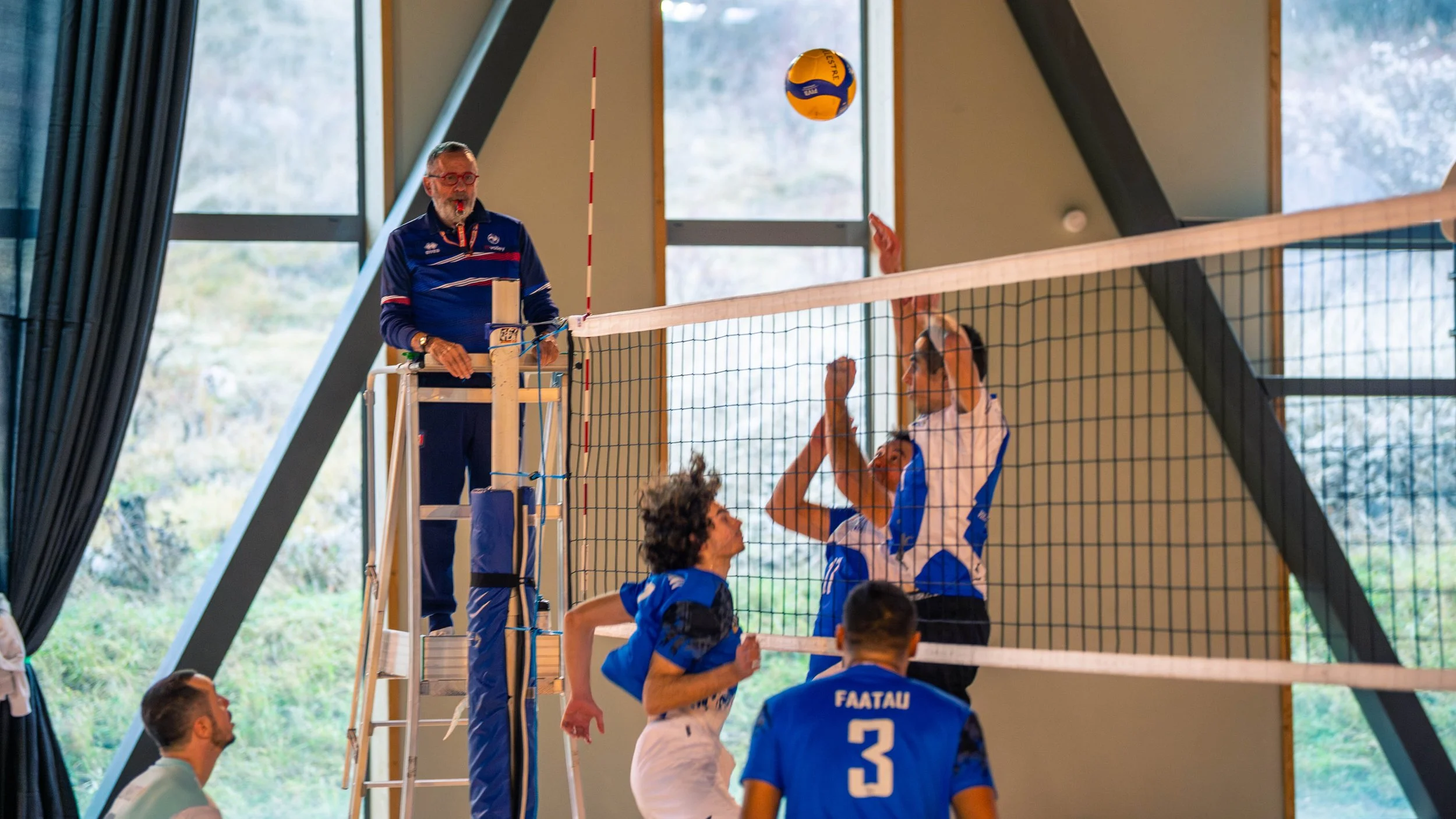 Joueurs de volleyball en action lors d'un match intérieur.