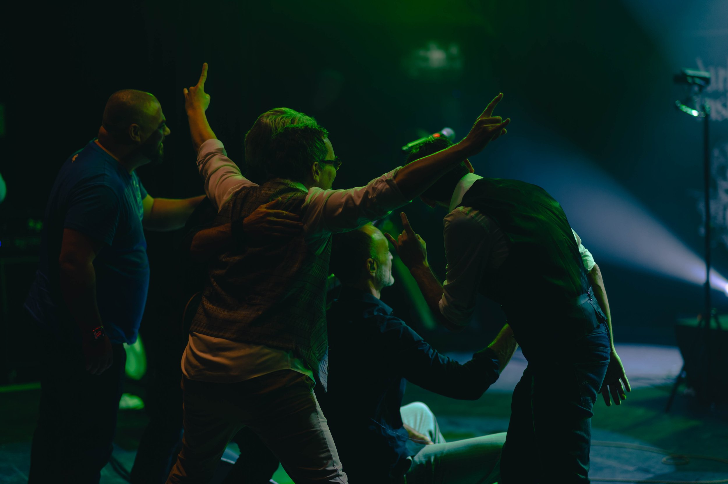 Groupe de personnes en train de danser et de s'amuser lors d'une fête ou d'un concert, sous un éclairage coloré