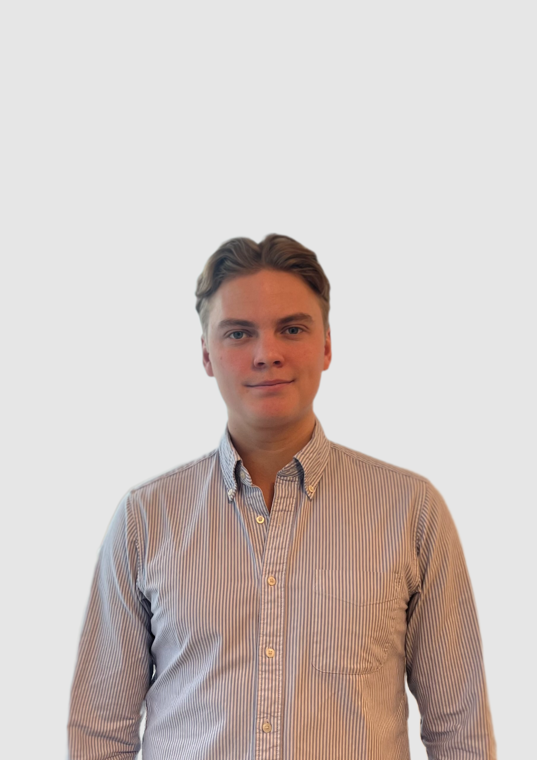 Portrait of a young man with light skin, brown hair, wearing a striped, button-down shirt, smiling slightly, against a plain background.