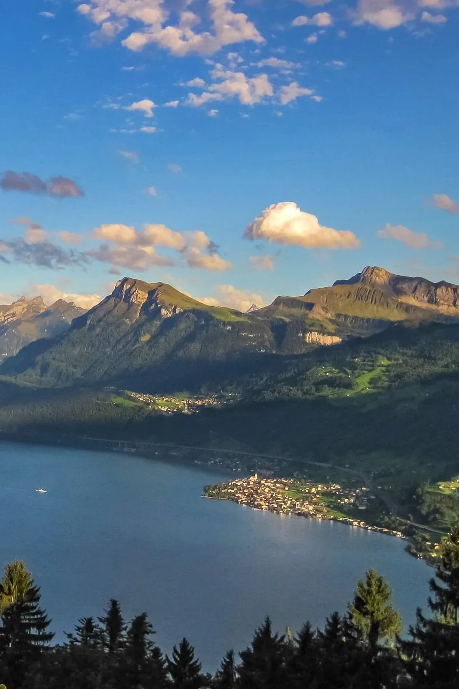 Berglandschaft mit See, Bergen und Wolken am Himmel bei Sonnenuntergang