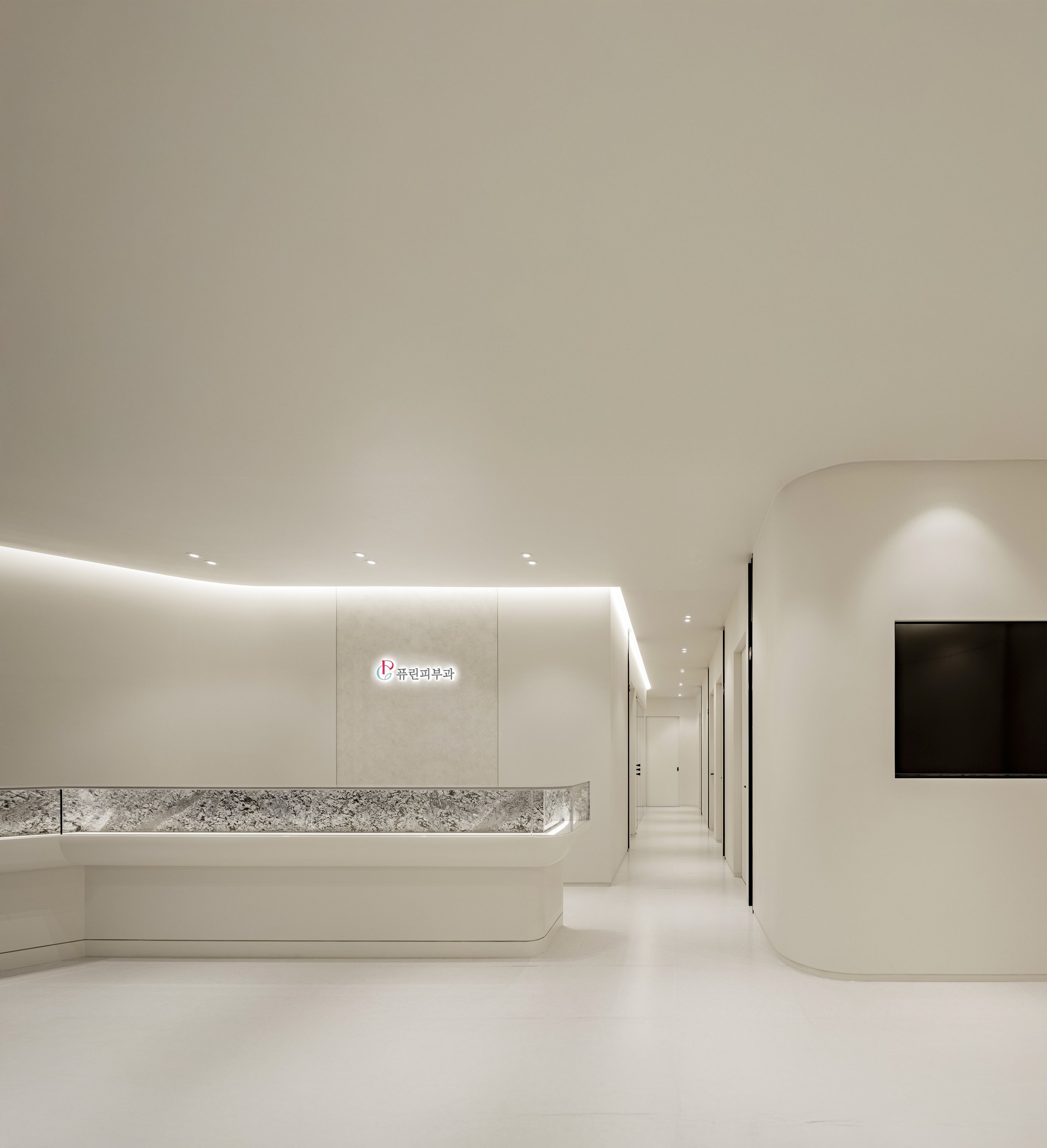 차분하고 정돈된 분위기의 퓨린피부과 접수 공간 내부 전경. Minimal interior of Pureen Dermatology clinic reception area, designed to reflect a calm and structured medical environment.