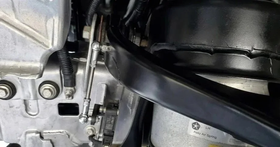 Ram 1500 rear suspension showing adjustable lowering link installed on ride height sensor