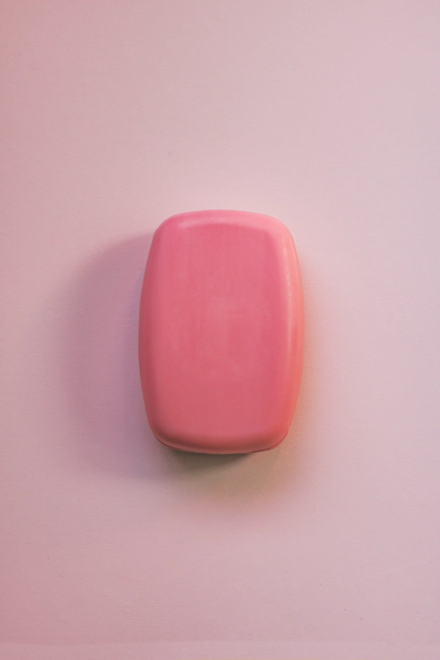 Pink soap bar on a pink surface.