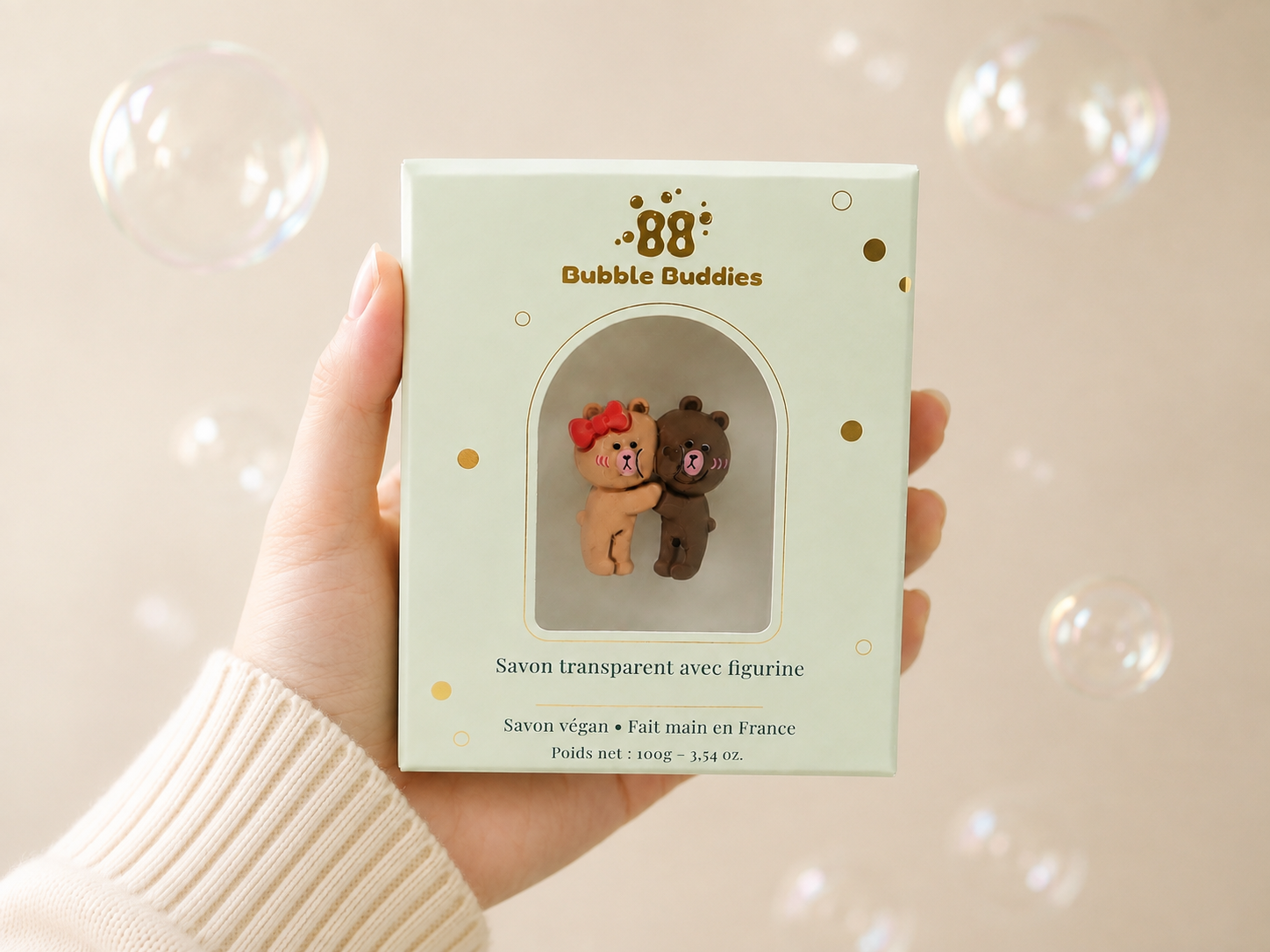 Hand holding bubble buddies transaprent handmade soap with collectible cute teddy bear figurine, made in France