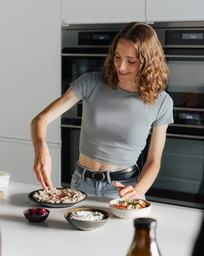Maya Leinenbach plating vegan dishes at a white kitchen counter during the Plantiful Cooking shoot