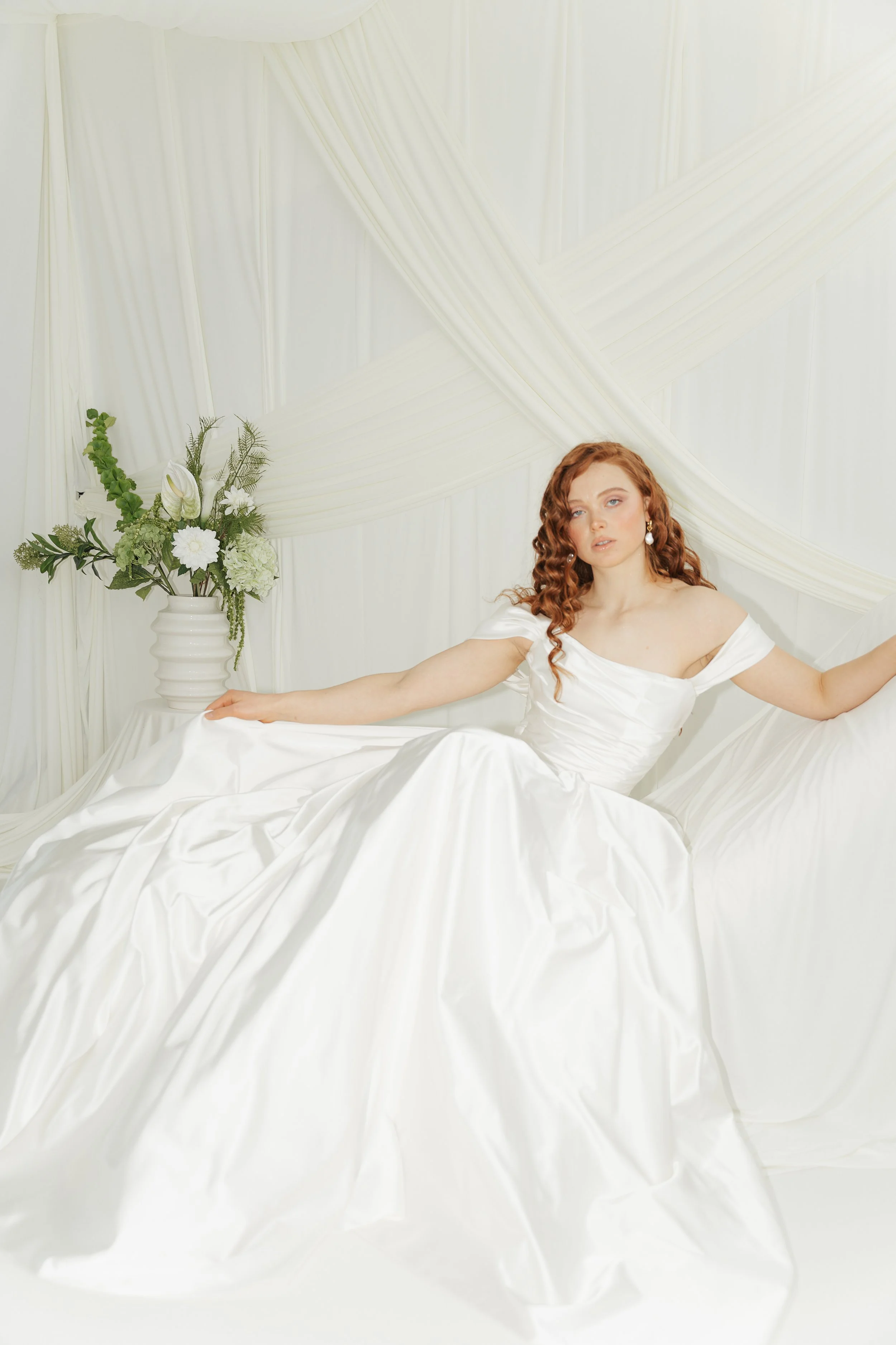 Editorial bridal portrait in a minimalist studio setting, focused on elegance, texture and timeless femininity.
