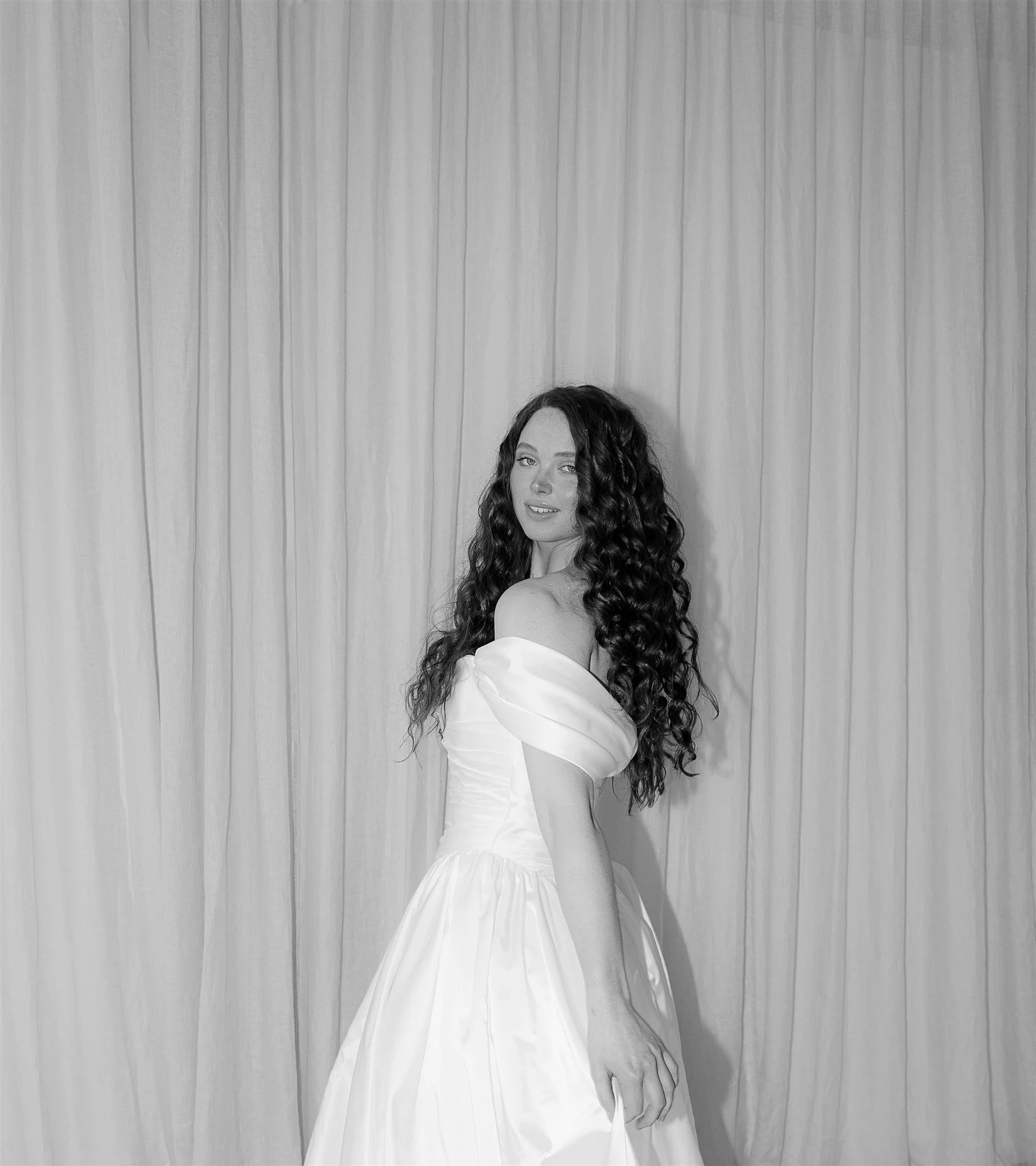 Editorial bridal portrait in a minimalist studio setting, focused on elegance, texture and timeless femininity.