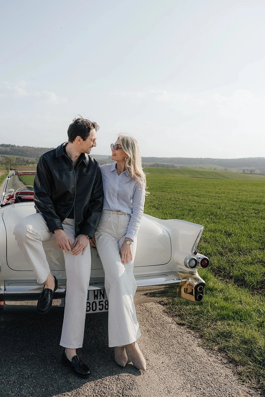 Couple sitting side by side on a white vintage Cadillac – Old Hollywood editorial by Anna van der Veen