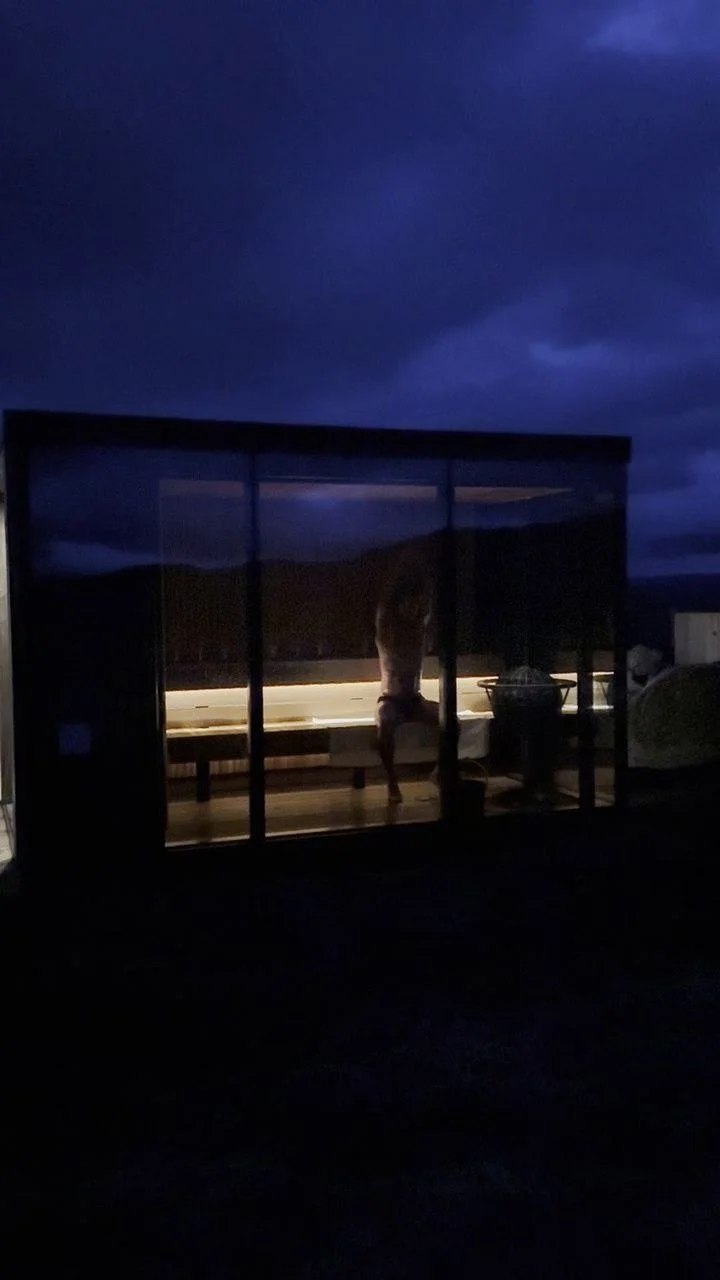 ÖÖD Hekla Horizon mirror suite glowing from inside at blue hour, under a dark Icelandic sky
