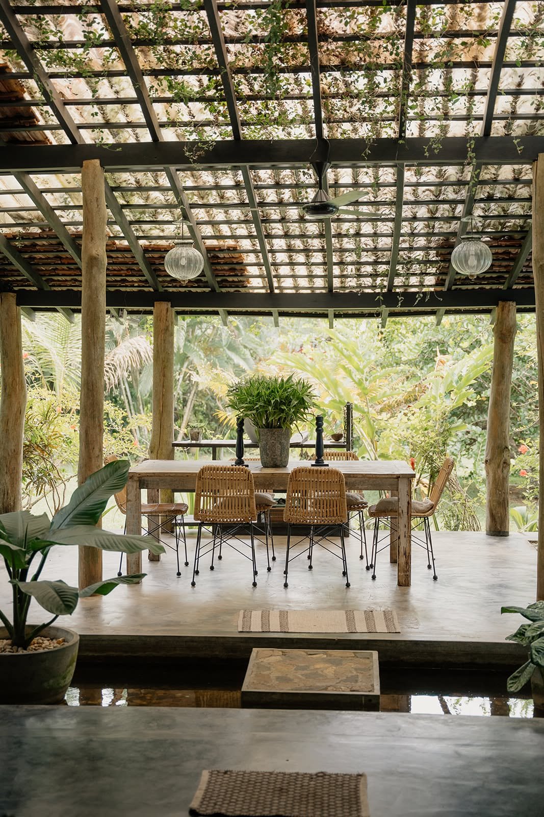 Open-air dining pavilion with a wooden table under a pergola roof, surrounded by tropical greenery at Huma Terra Lodge, Sri Lanka