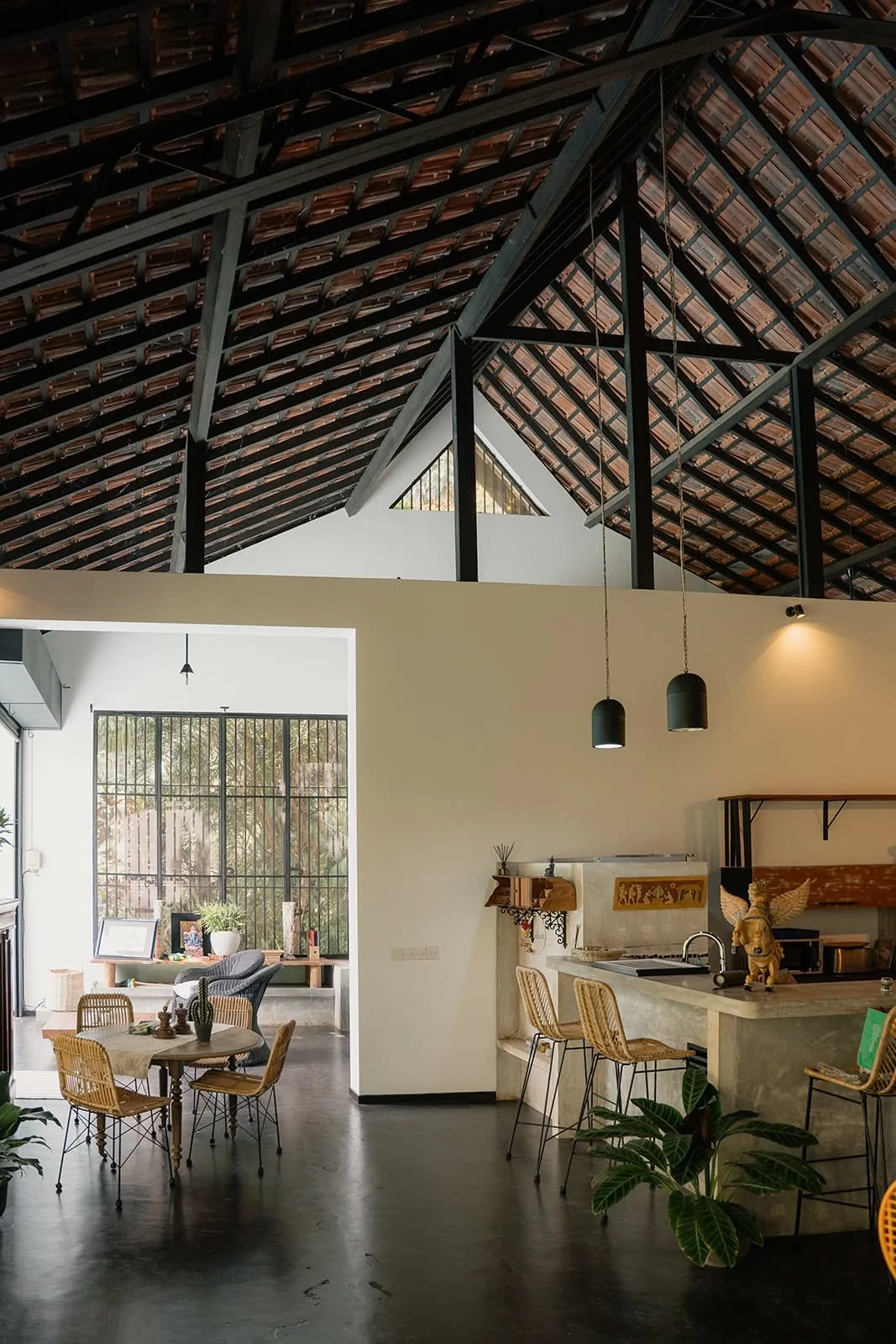 Open living space with a kitchen, pendant lamps and a high timber roof at Huma Terra Lodge, Sri Lanka