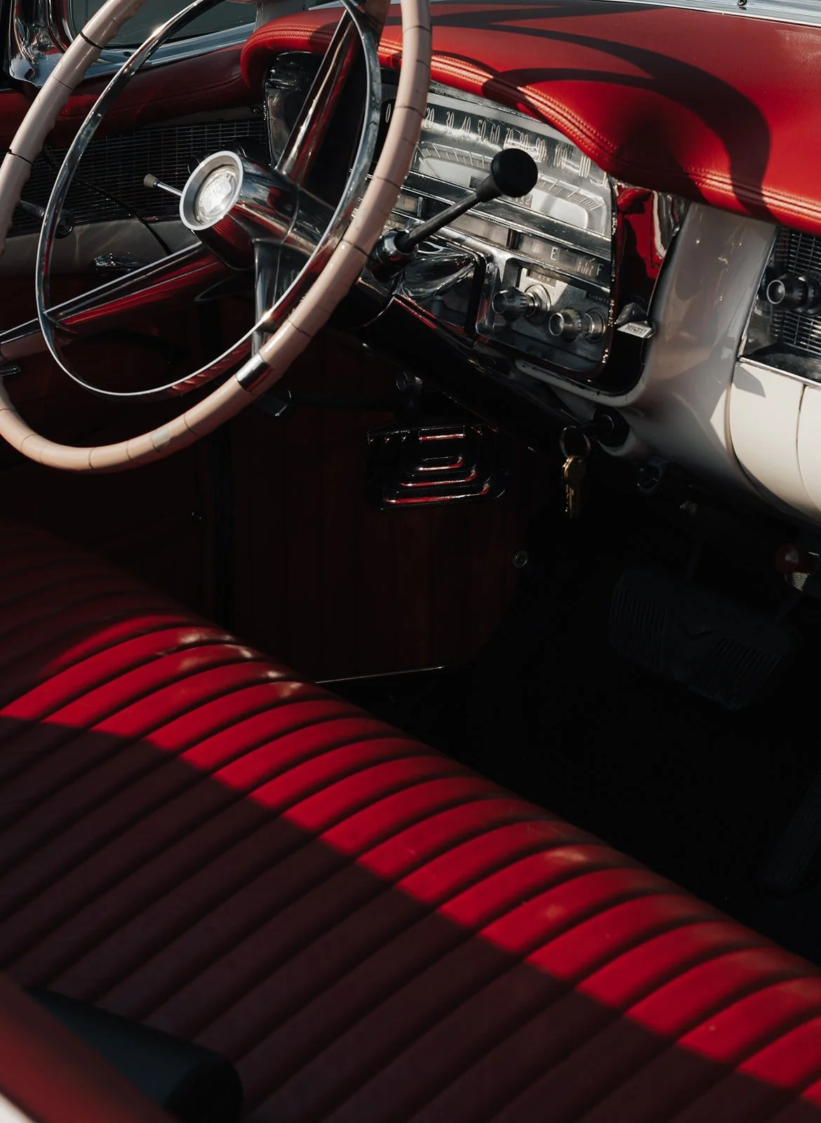 Red leather seats and steering wheel of a vintage Cadillac – Old Hollywood editorial by Anna van der Veen