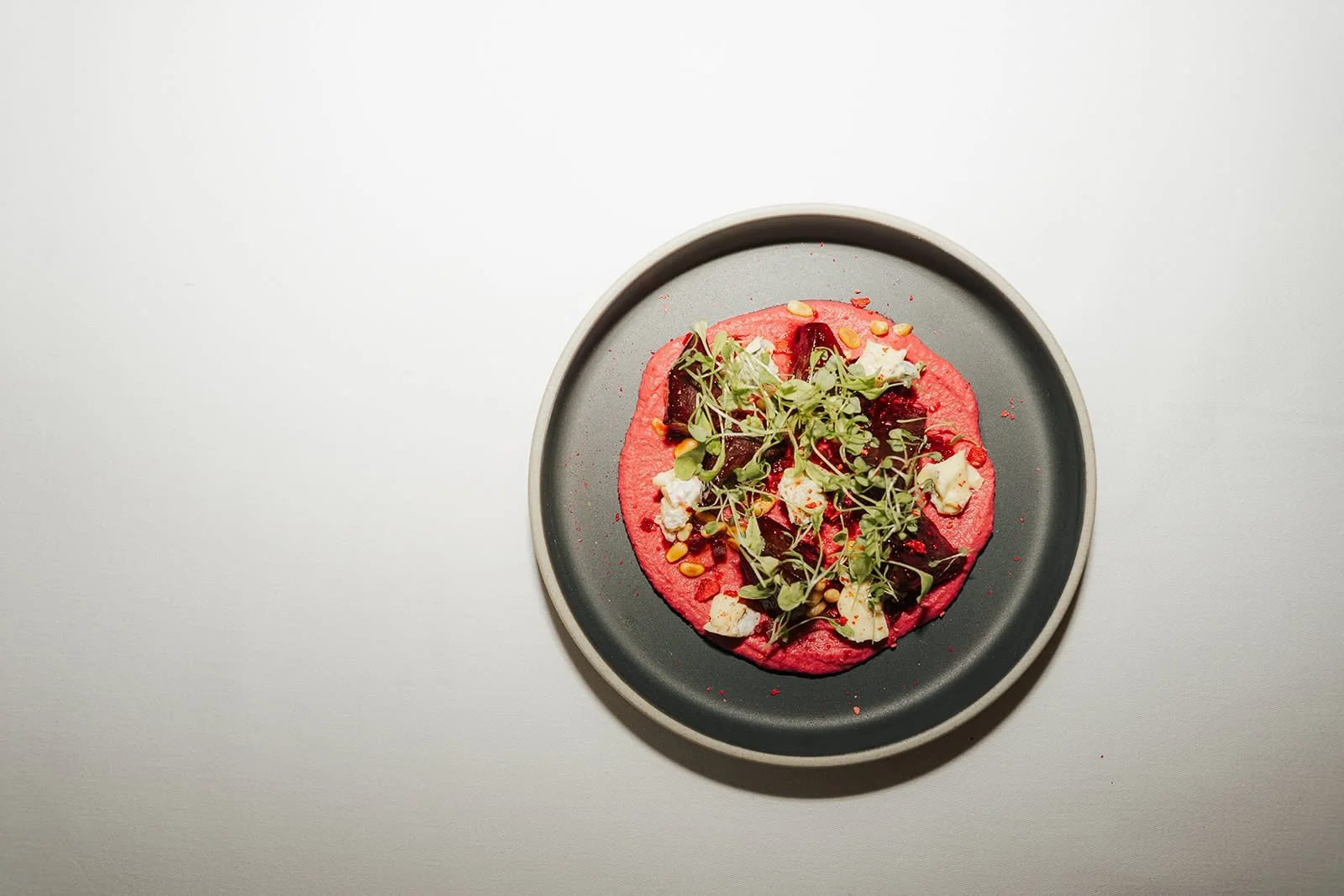 Beetroot dish with fresh herbs on a dark plate, served at Hótel Búðir, Iceland