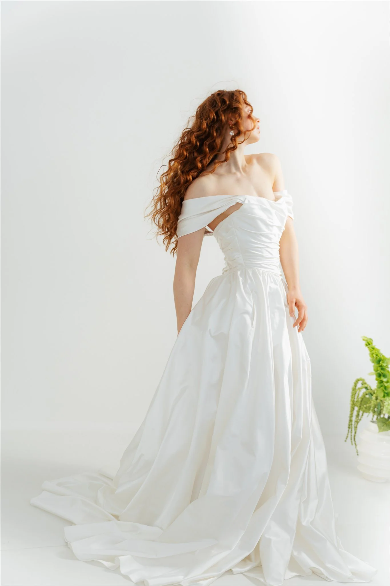Editorial bridal portrait in a minimalist studio setting, focused on elegance, texture and timeless femininity.