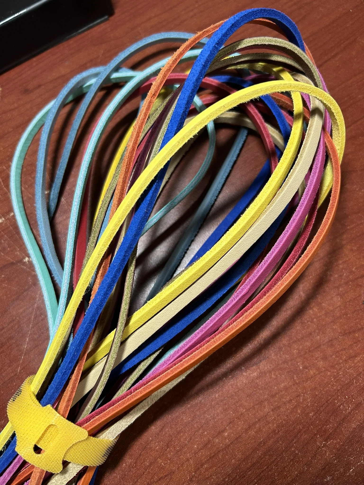 A bunch of colorful elastic hair bands on a wooden surface.