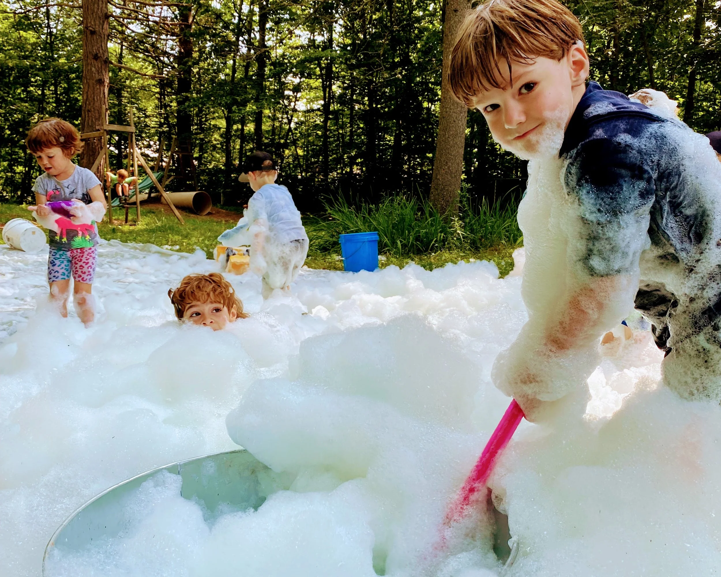 children playing with foam and water during outdoor sensory play