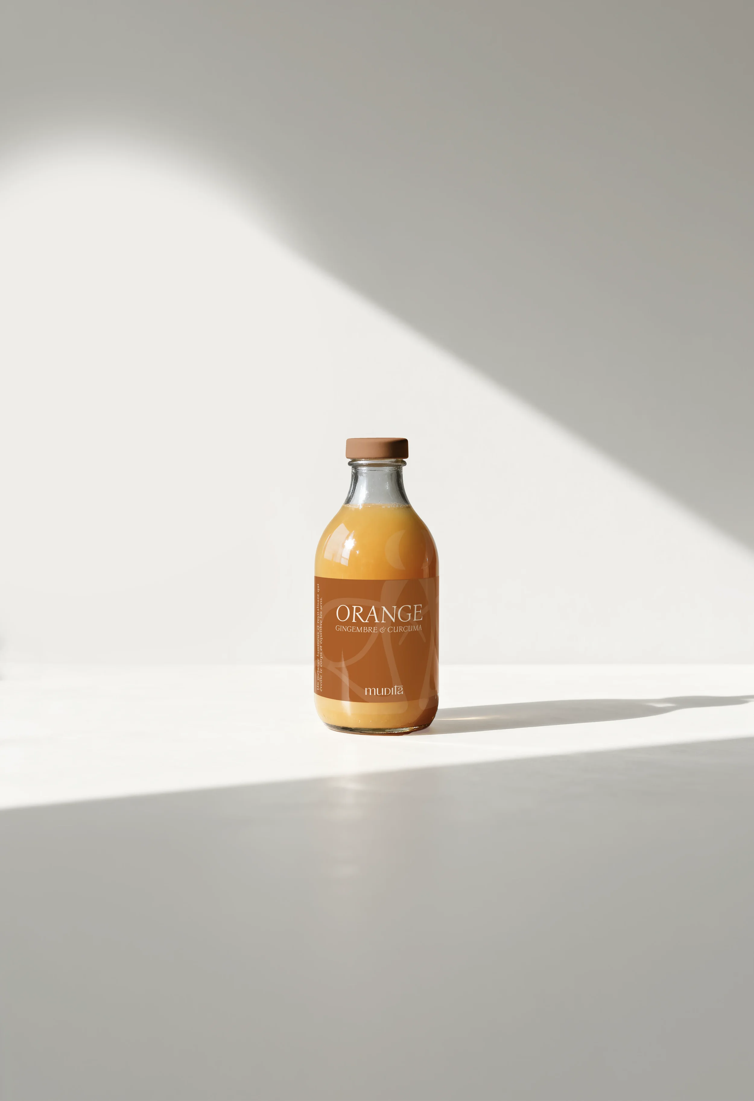 Botella de jugo de naranja con etiqueta que dice 'Orange' y menciona jengibre y cúrcuma, sobre fondo blanco con sombra.