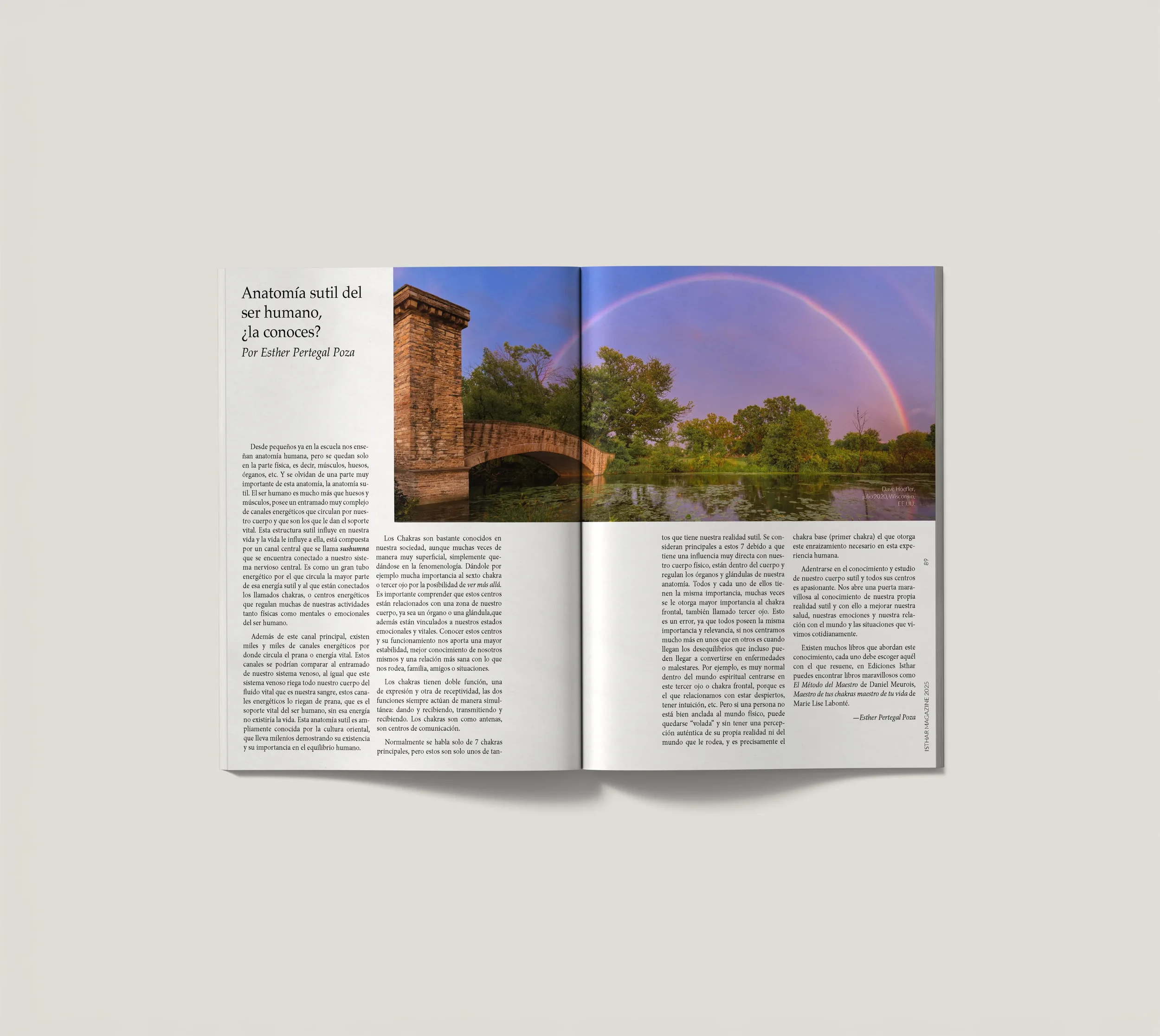 Revista abierta con artículo y foto de un puente de piedra y un arcoíris sobre un río en un entorno natural