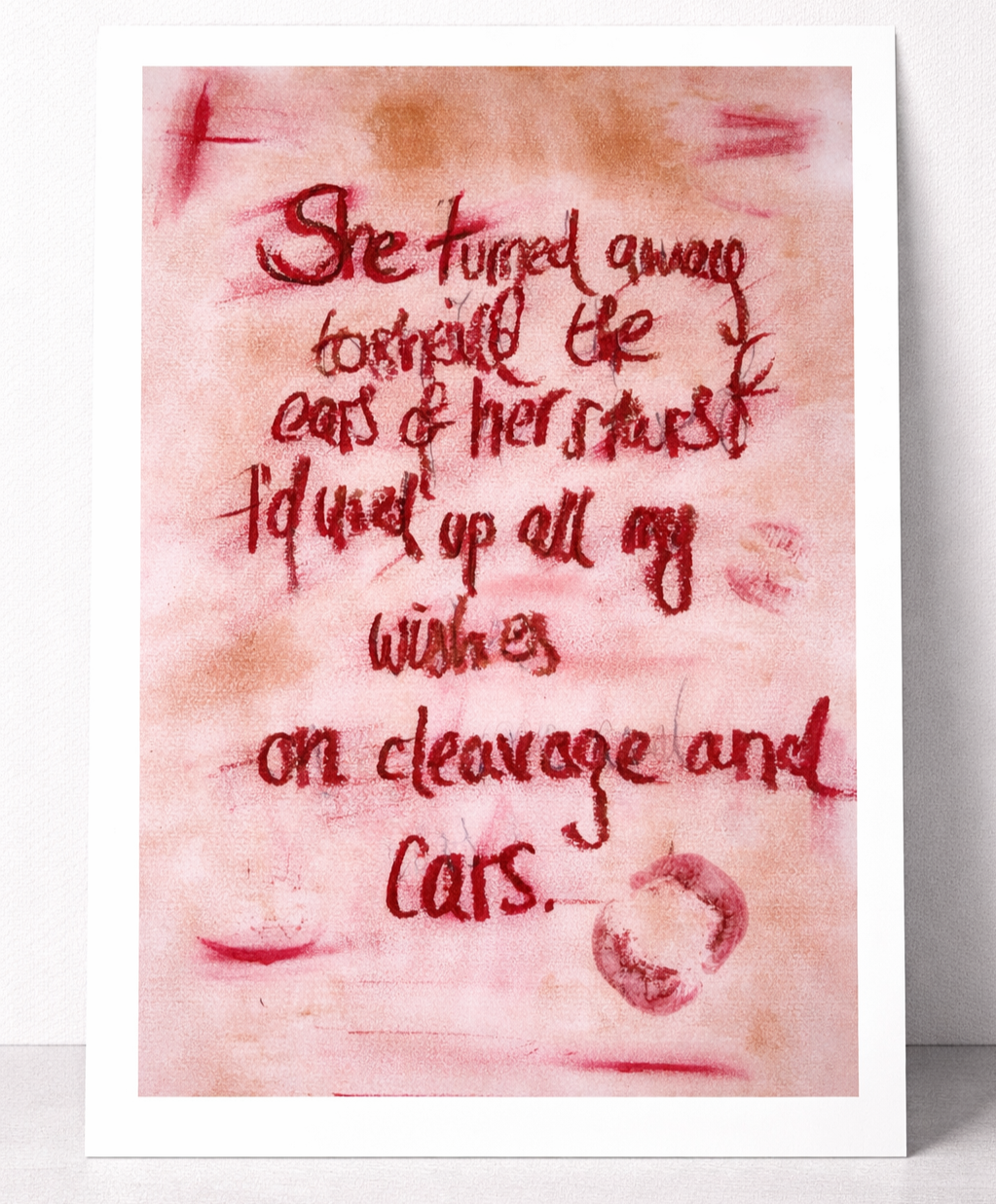 A handwritten note in red ink on pinkish paper, stating, "She turned away to shield the ears of her stars, I'd used up all my wishes on cleavage and cars," with a lipstick kiss mark at the bottom.