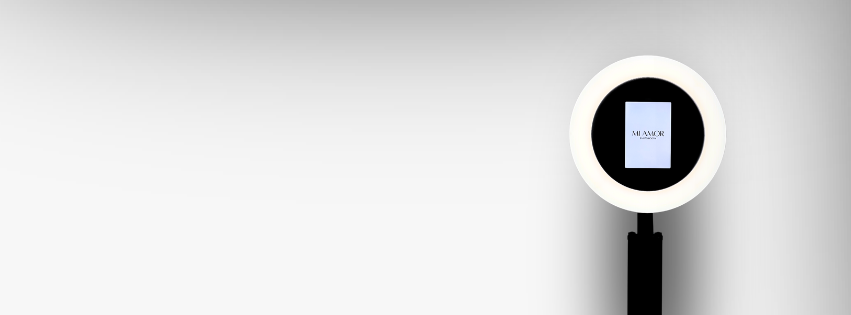 A photo showing a ring light photo station with a digital tablet or screen displaying the word 'Mi Amor' on a white background.