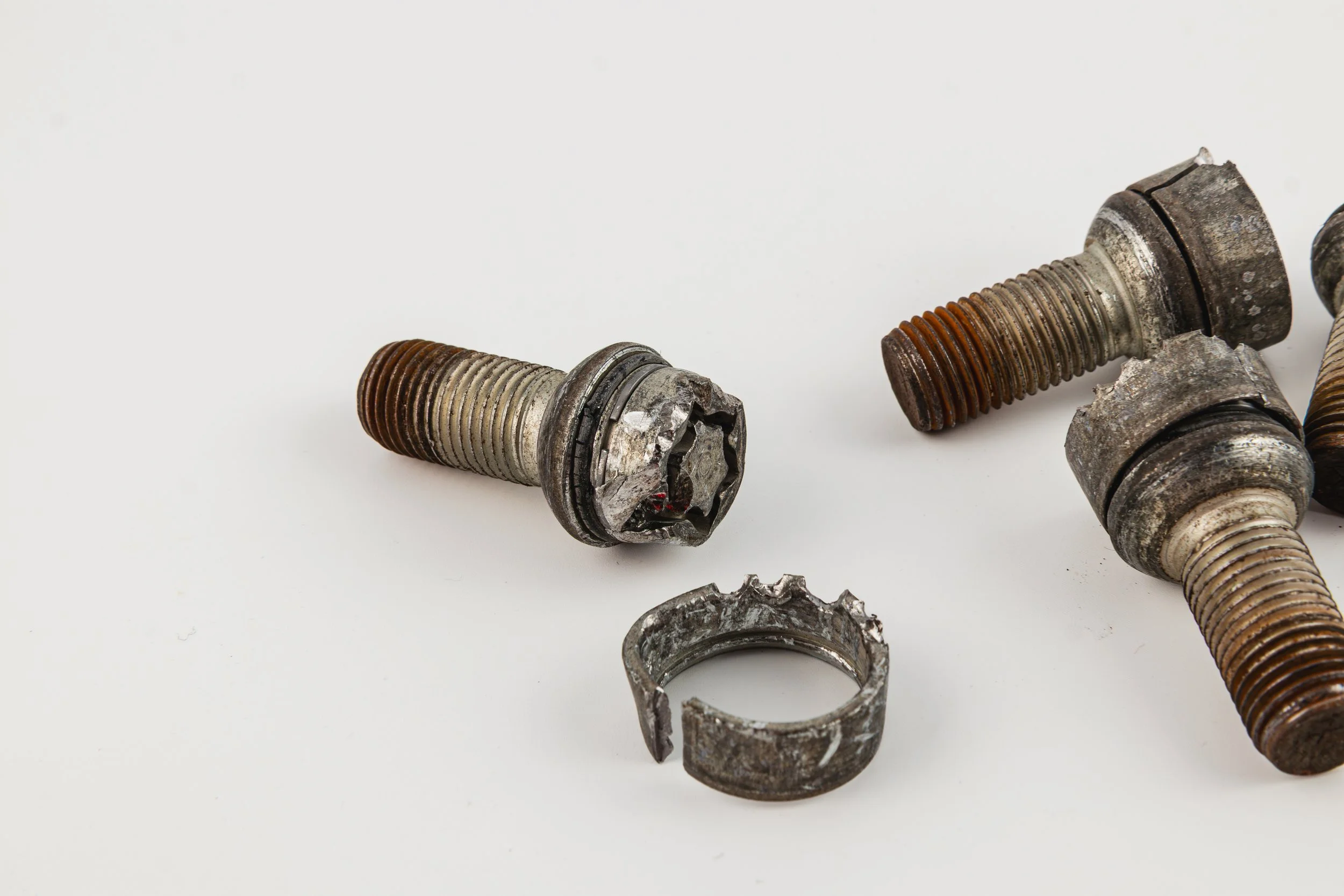 Rusty metal bolts and retaining ring showcasing wear and tear