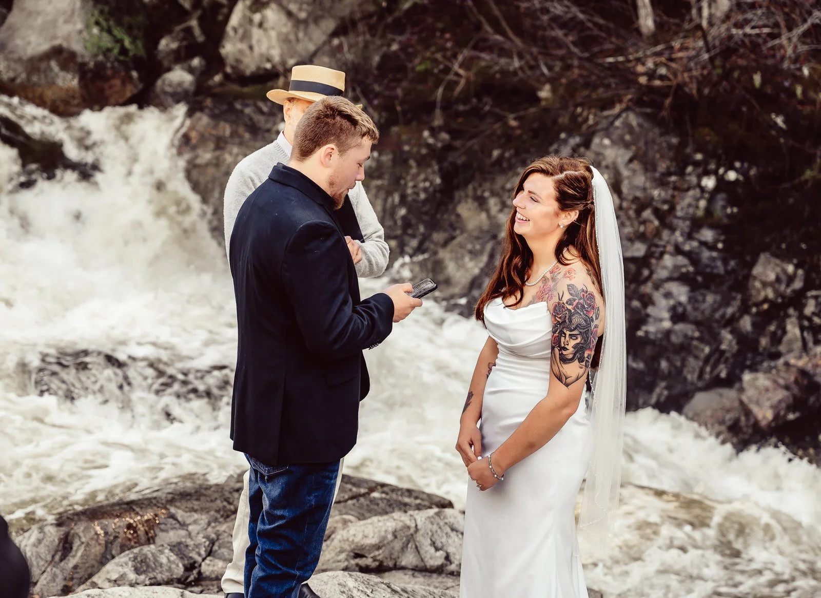 happy couple sharing vows beside New Hampshire waterfall