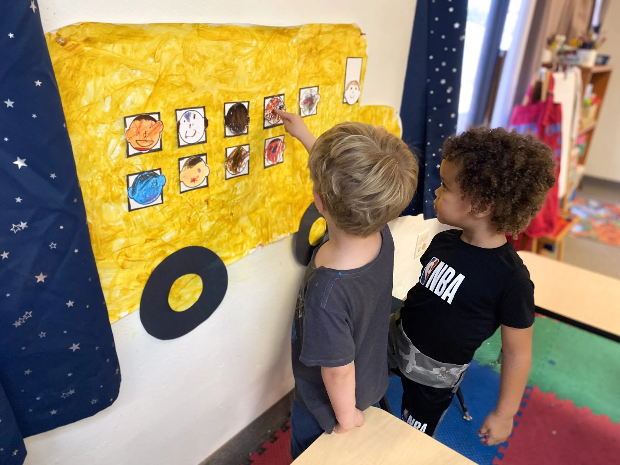 Two young boys looking at a bulletin board. ABA Early Intervention Clinic in Chanlder, Arizona.