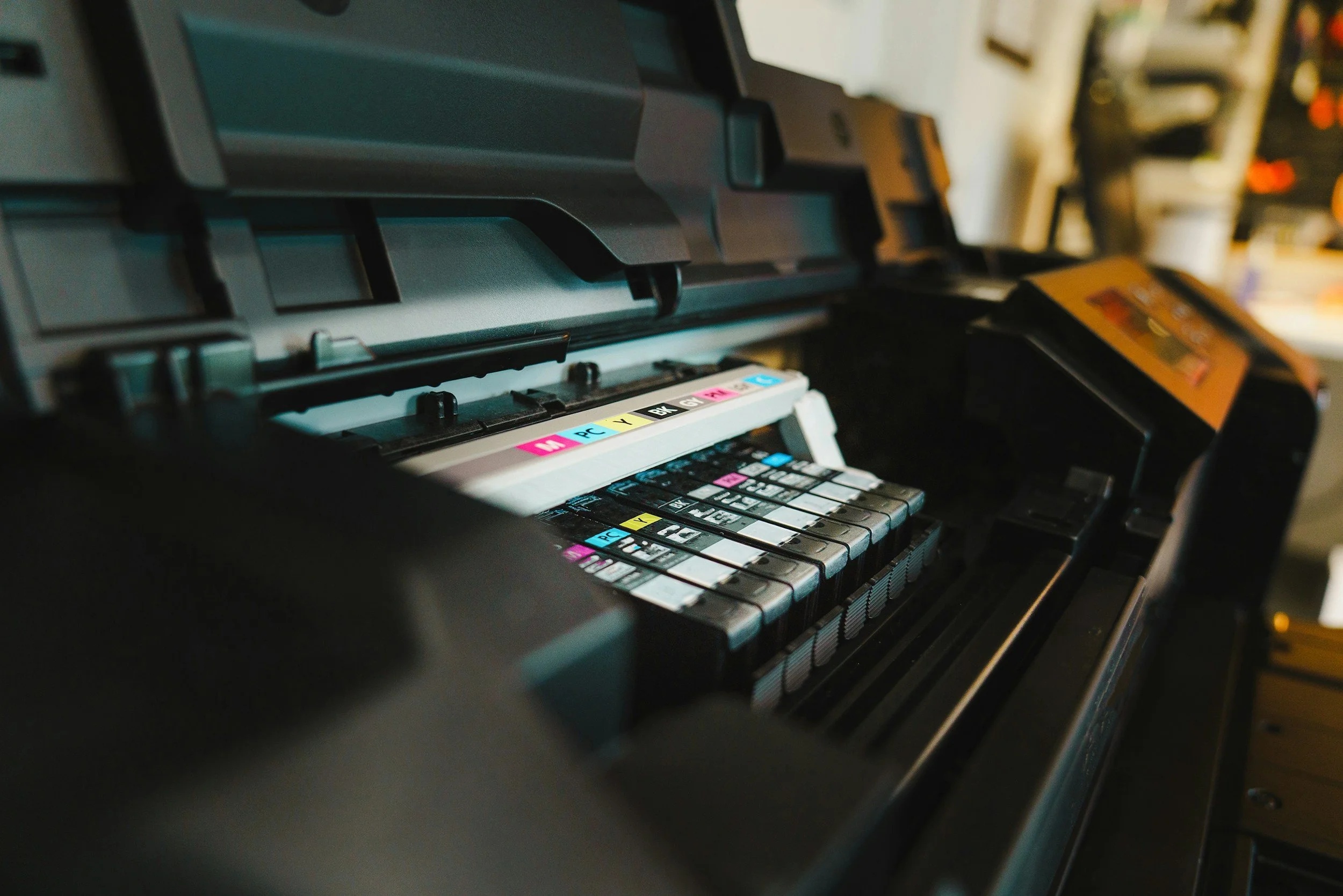 Close-up of a printer showing colorful ink cartridges and internal components.