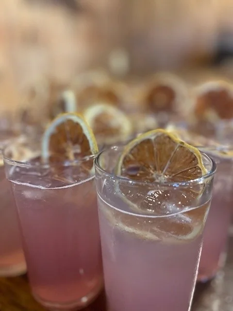 Pink beverages with lemon slices garnish in clear glasses