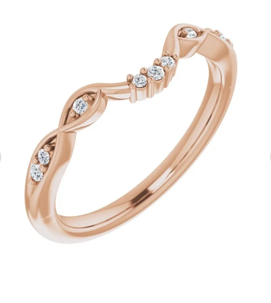 A close-up of a rose gold ring with embedded small diamonds, featuring a leaf-like design.