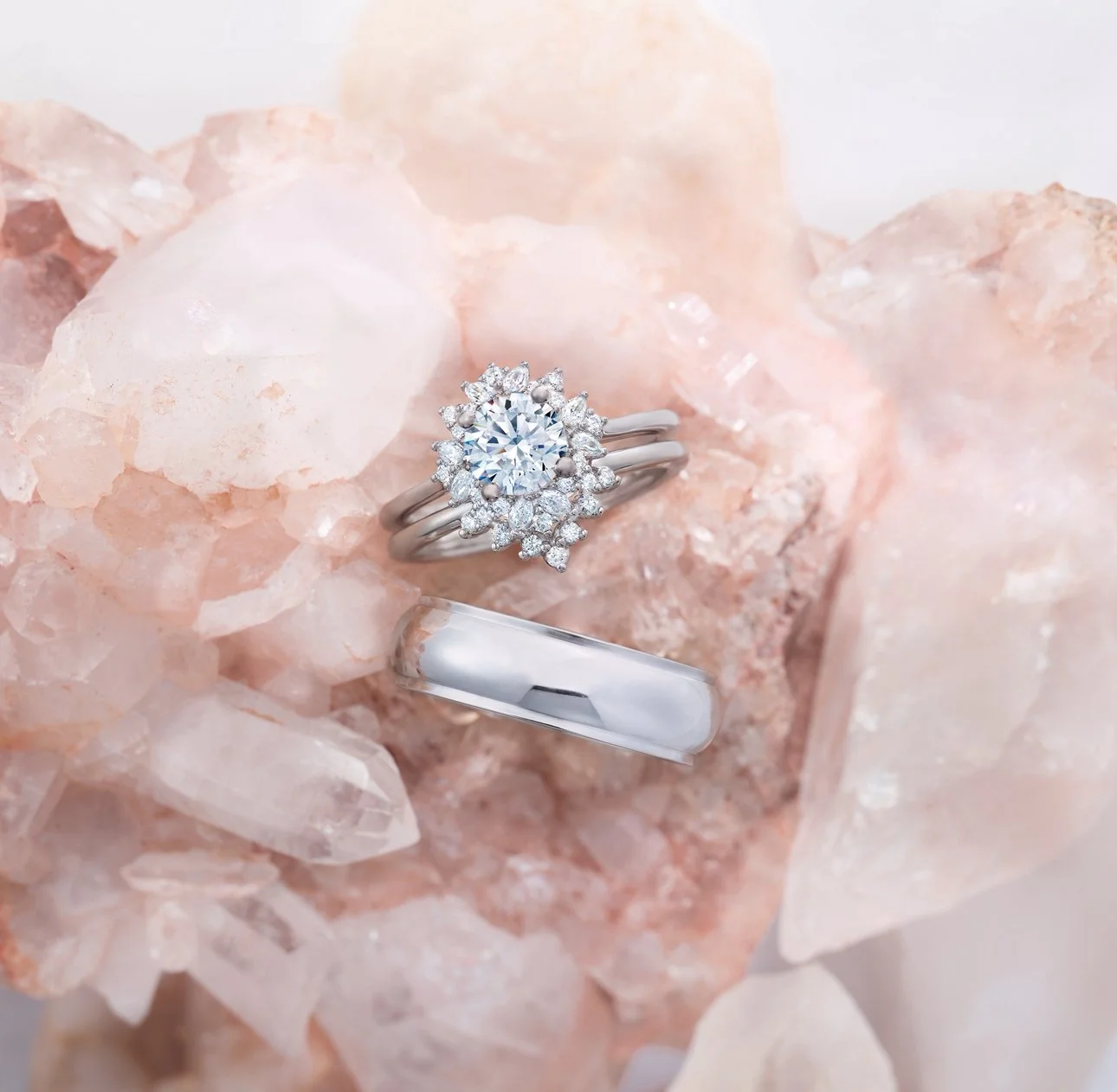 A sparkling diamond engagement ring with a halo setting on a cluster of pink Himalayan salt crystals.