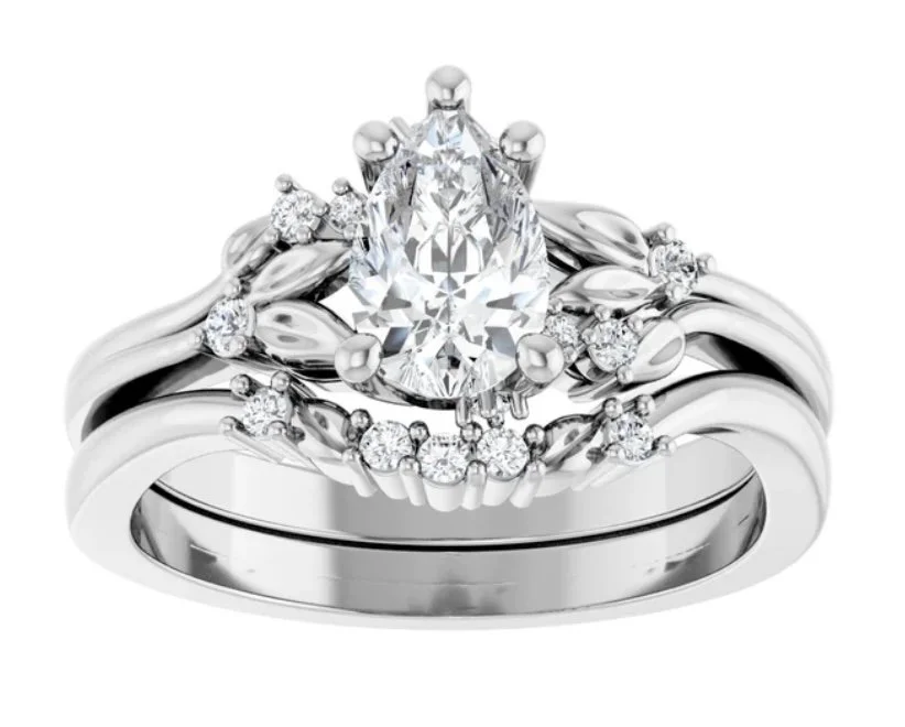 Silver engagement ring with a large central teardrop-shaped diamond and smaller diamonds surrounding it.