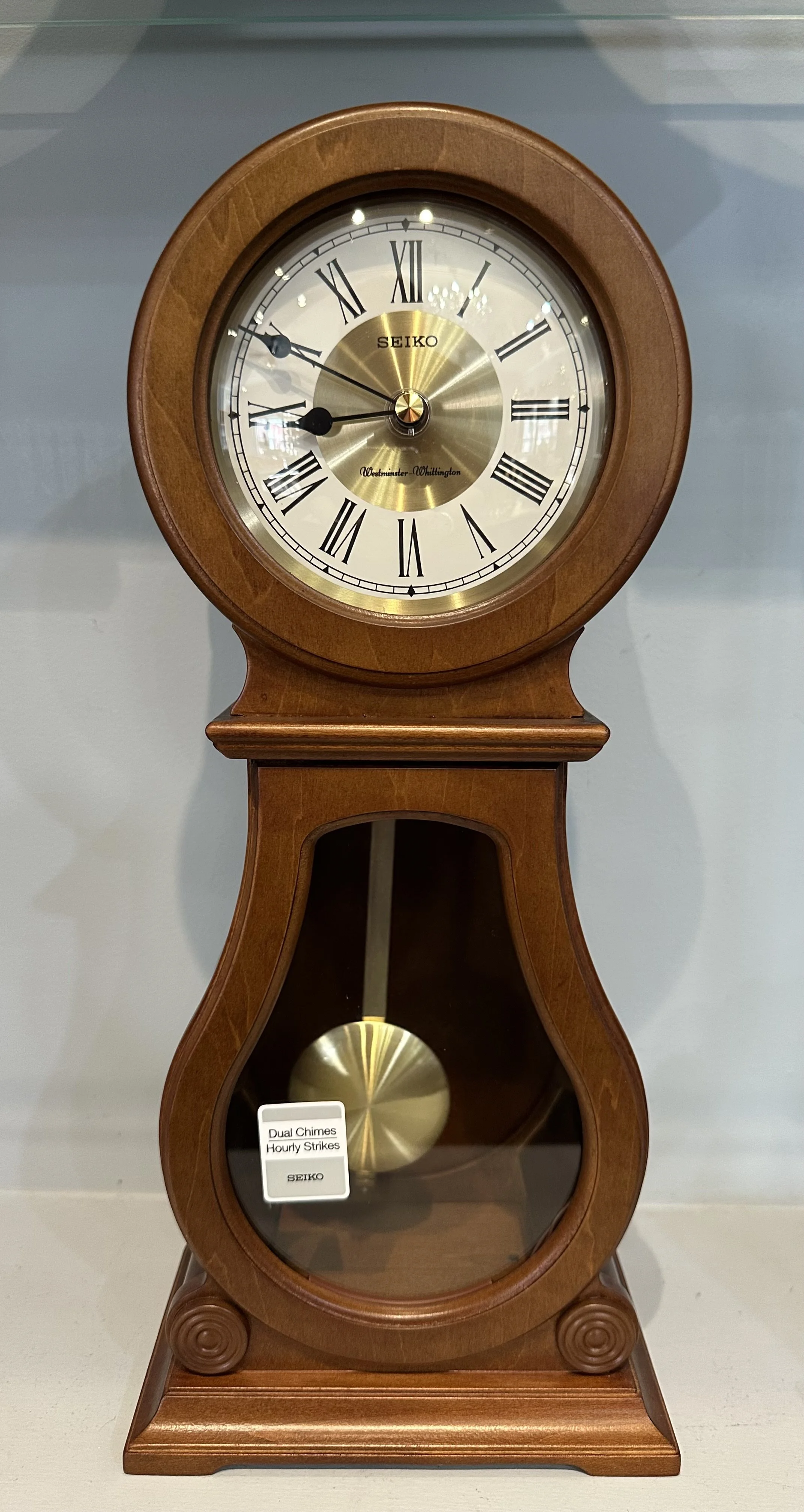 A vintage Seiko wall clock with wooden frame and pendulum, featuring Roman numerals and dual chimes with hourly strikes.