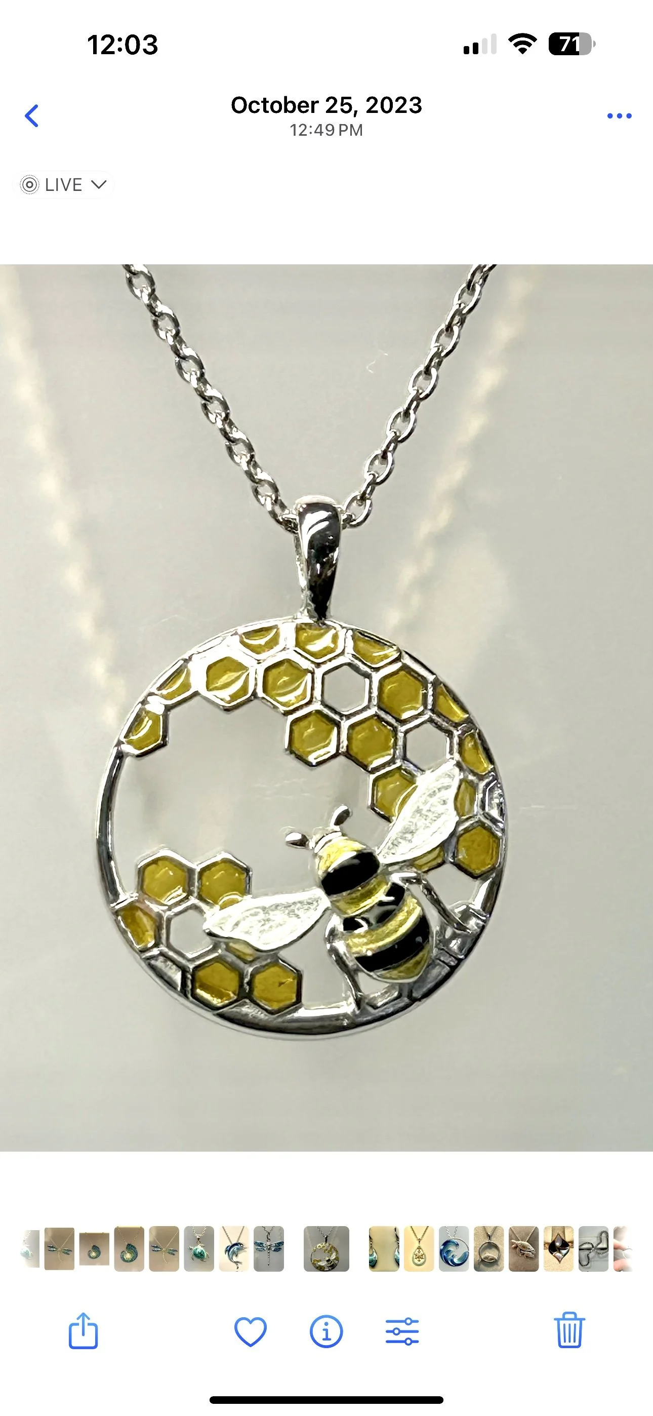 A silver necklace with a pendant featuring a honeybee surrounded by honeycomb shapes.