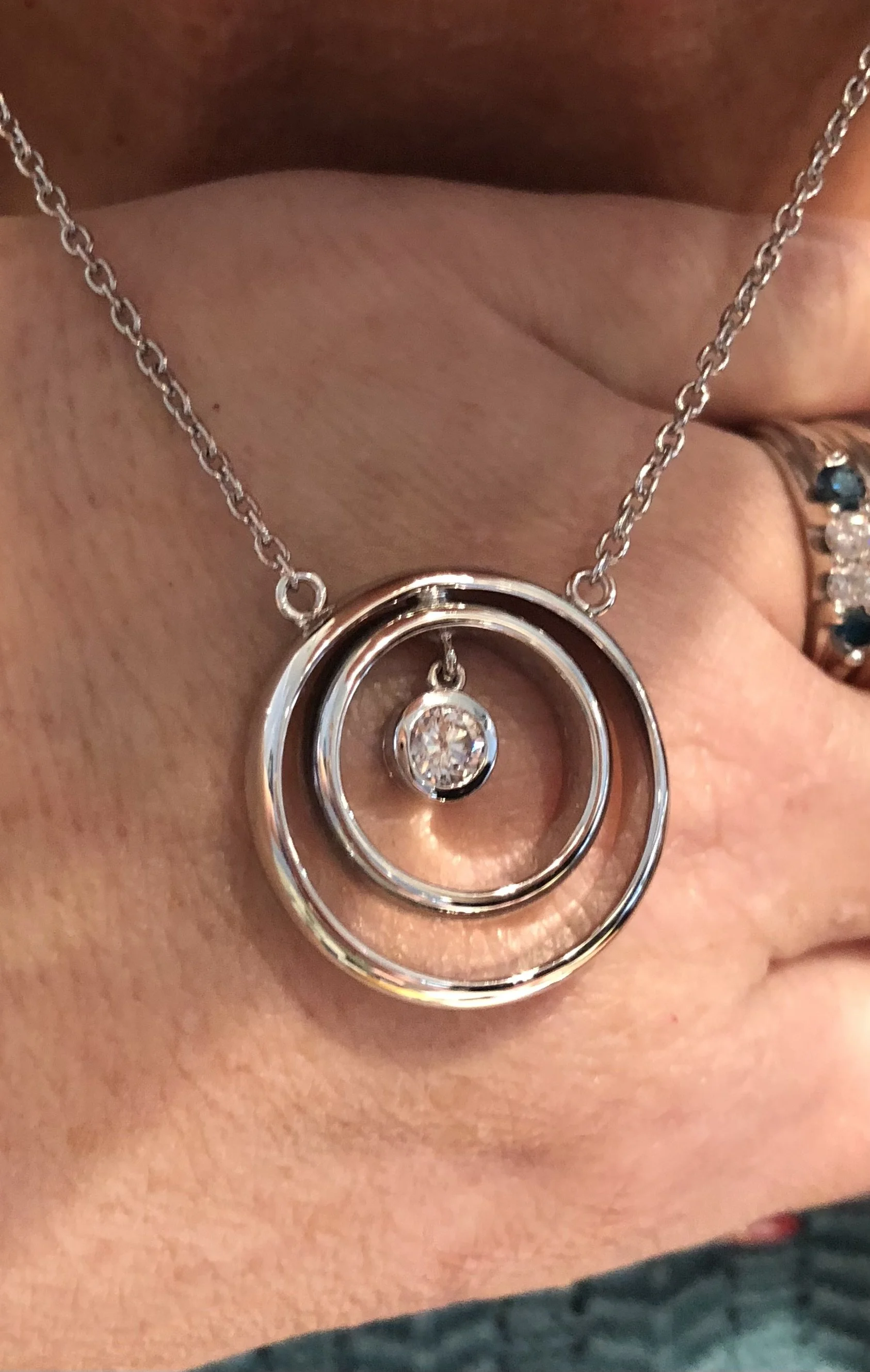 Necklace made from wedding bands and engagement diamond in center