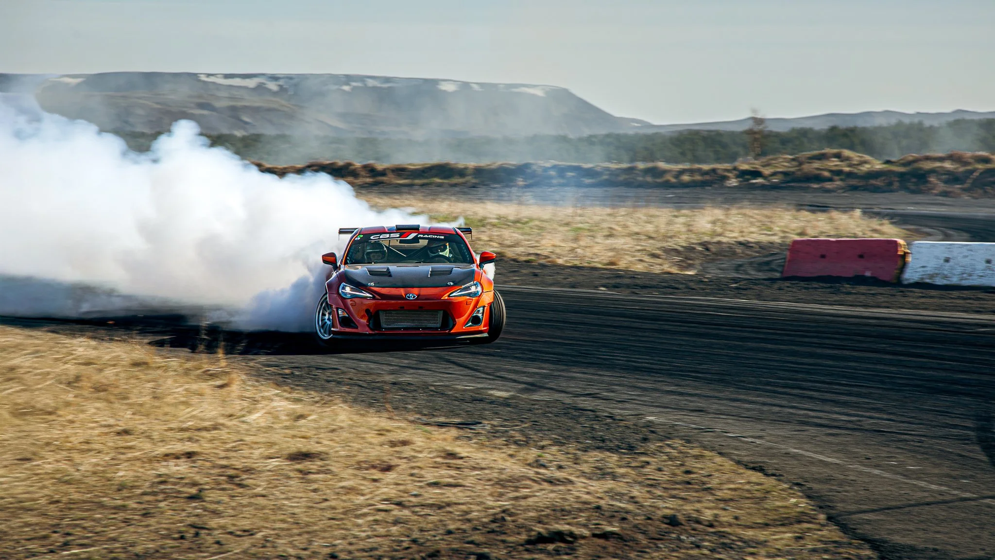 Drift car drifting on track with mountain in background