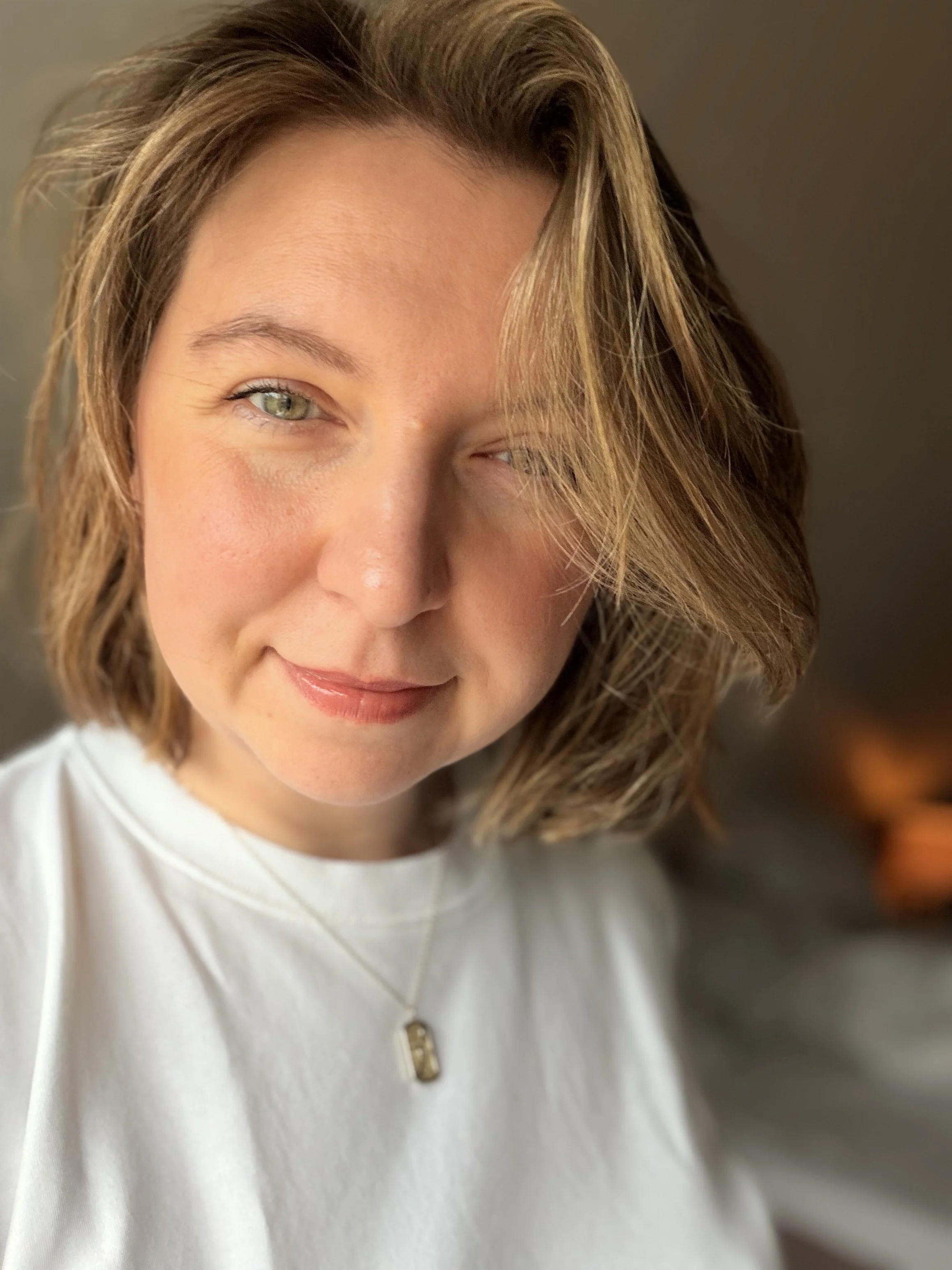 Nahaufnahme der Studioinhaberin Liz, sie trägt ein weißes Oberteil.