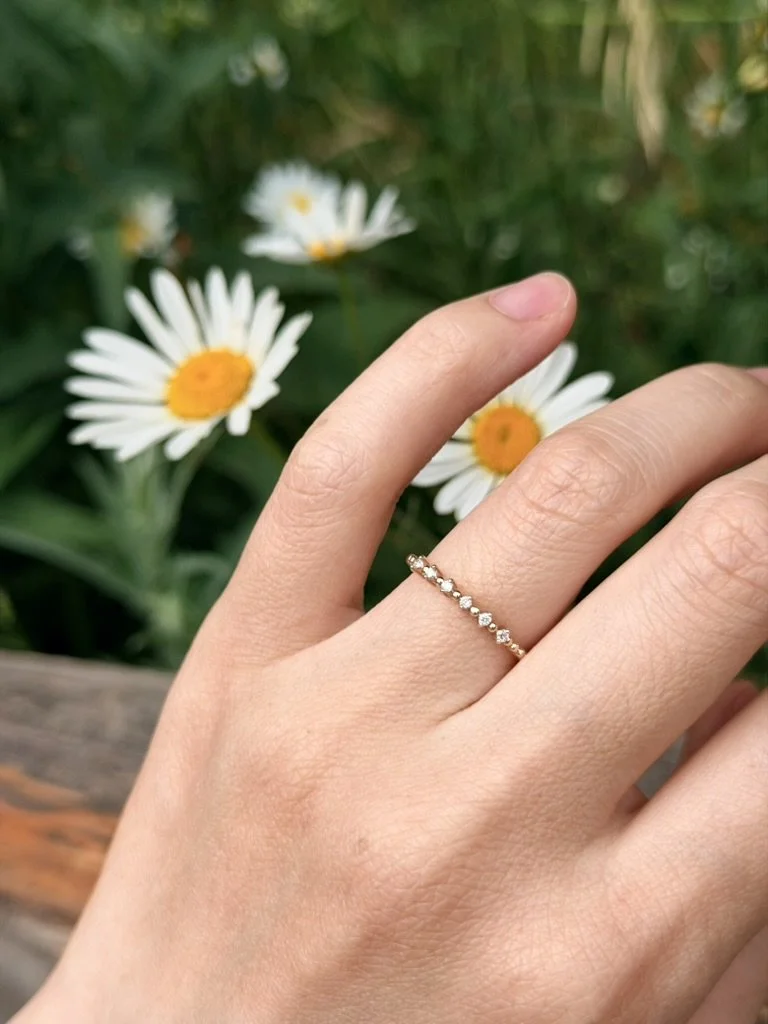 Ribbed band lab-grown diamond ring in 9ct yellow gold worn on the hand — spaced round brilliants on a ribbed rope band. Gugunava Jewelry, London.
