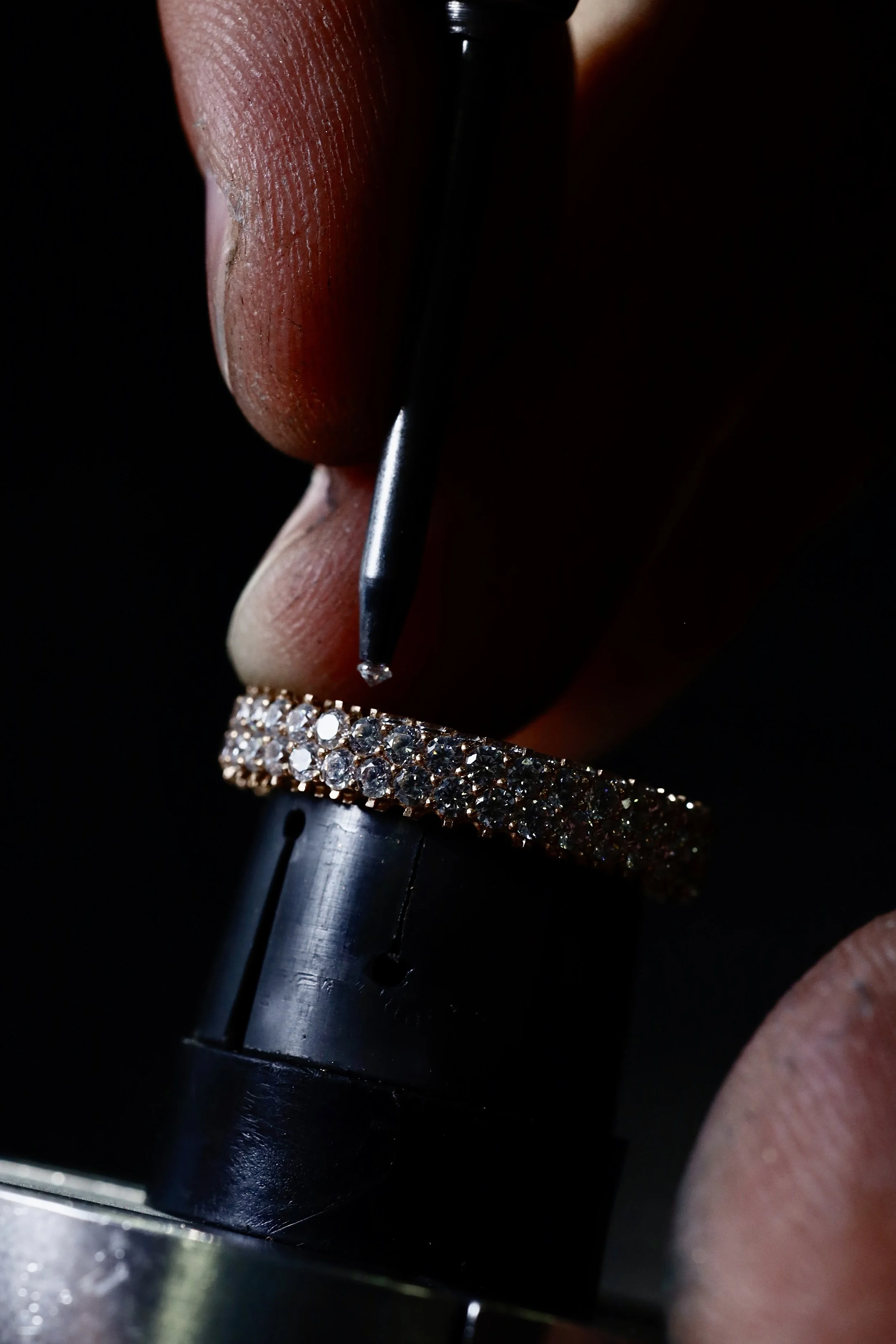 Setting diamonds into a three-sided full pavé eternity ring with a graver, hand setting work by Arsen Gugunava London
