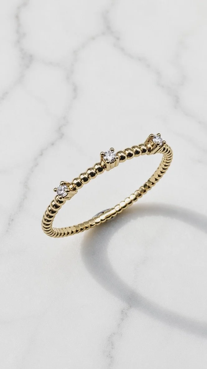 Yellow gold minimalist stacking ring with three round lab diamonds, claw set on a beaded band, handmade in London