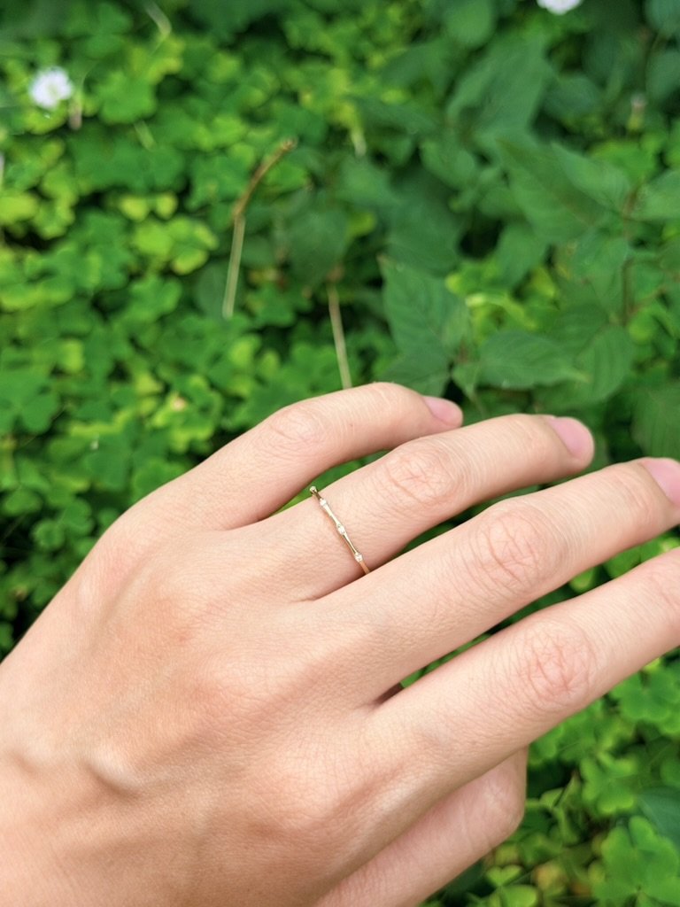 Flush-set lab-grown diamond ring in 9ct yellow gold worn on the hand — round brilliants flush-set into an organic, undulating band. Gugunava Jewelry, London.