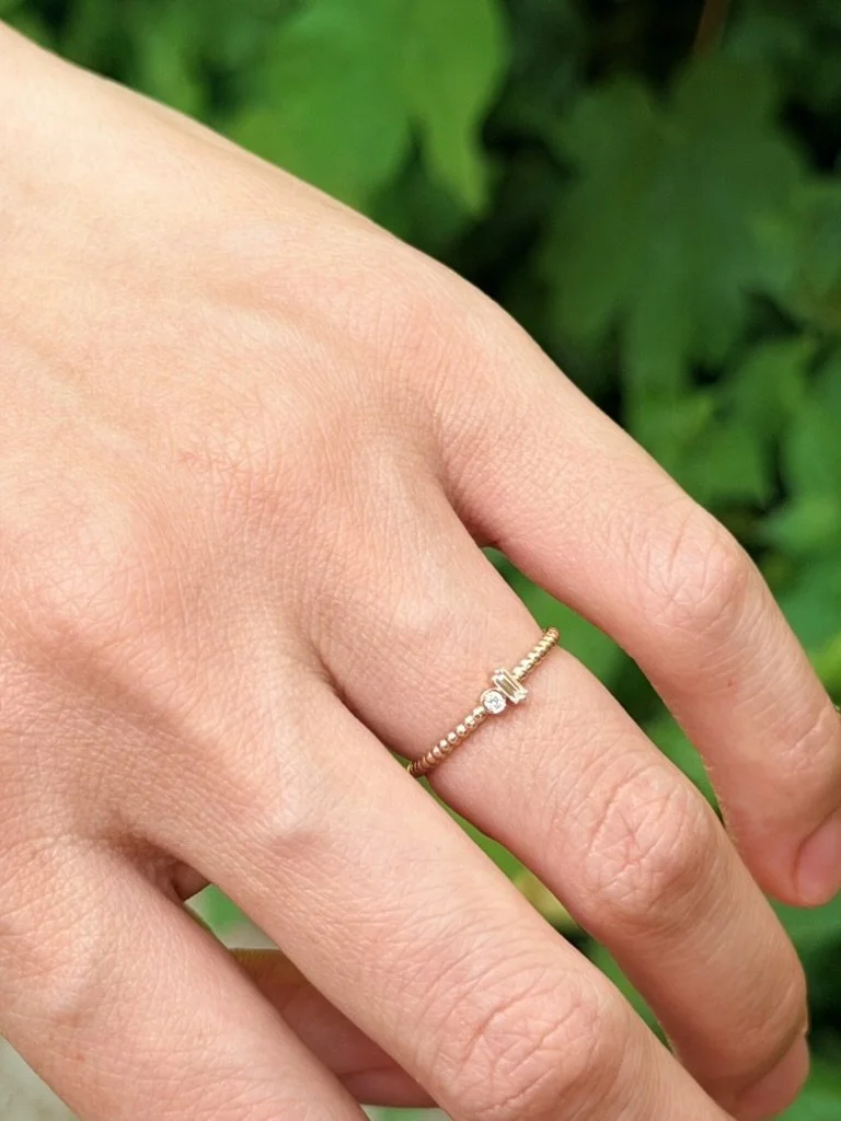 Two stone lab-grown diamond ring in 9ct yellow gold worn on the hand — a baguette and round brilliant set side by side on a beaded band. Gugunava Jewelry, London.
