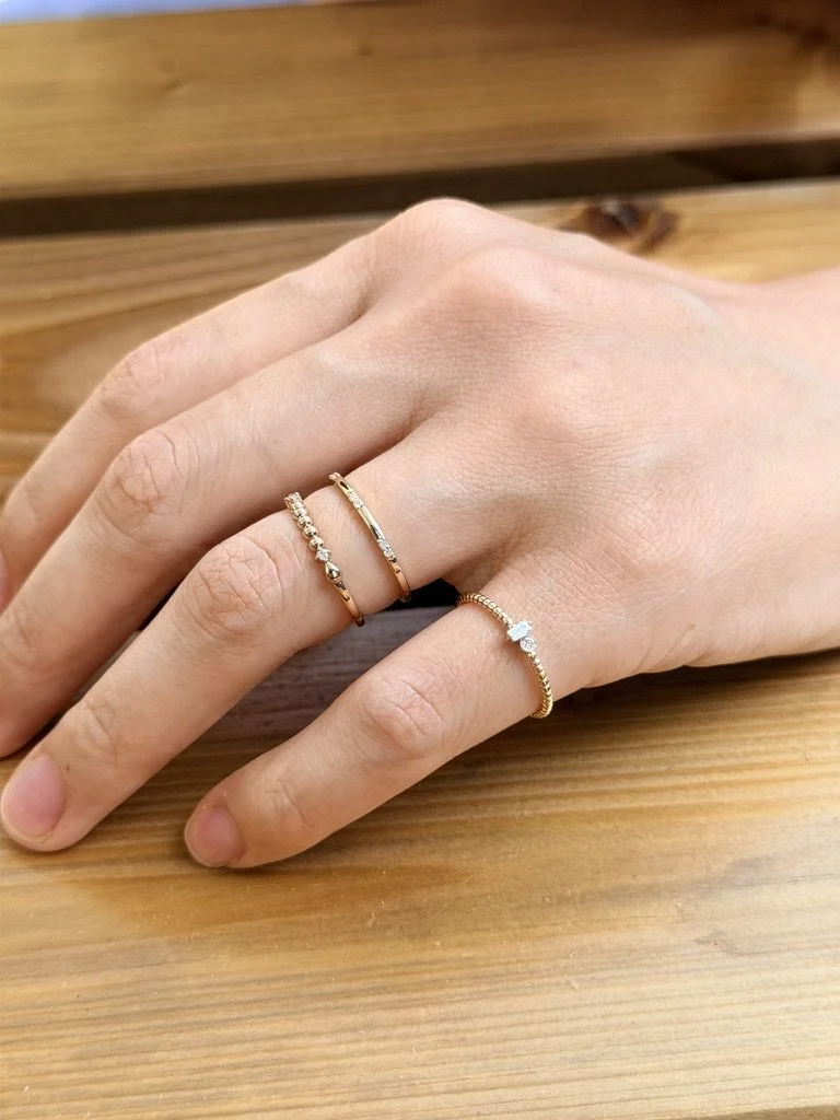 Beaded lab-grown diamond ring in 9ct yellow gold stacked with other rings from The Minimal Stack Edit, worn on the hand. Gugunava Jewelry, London.