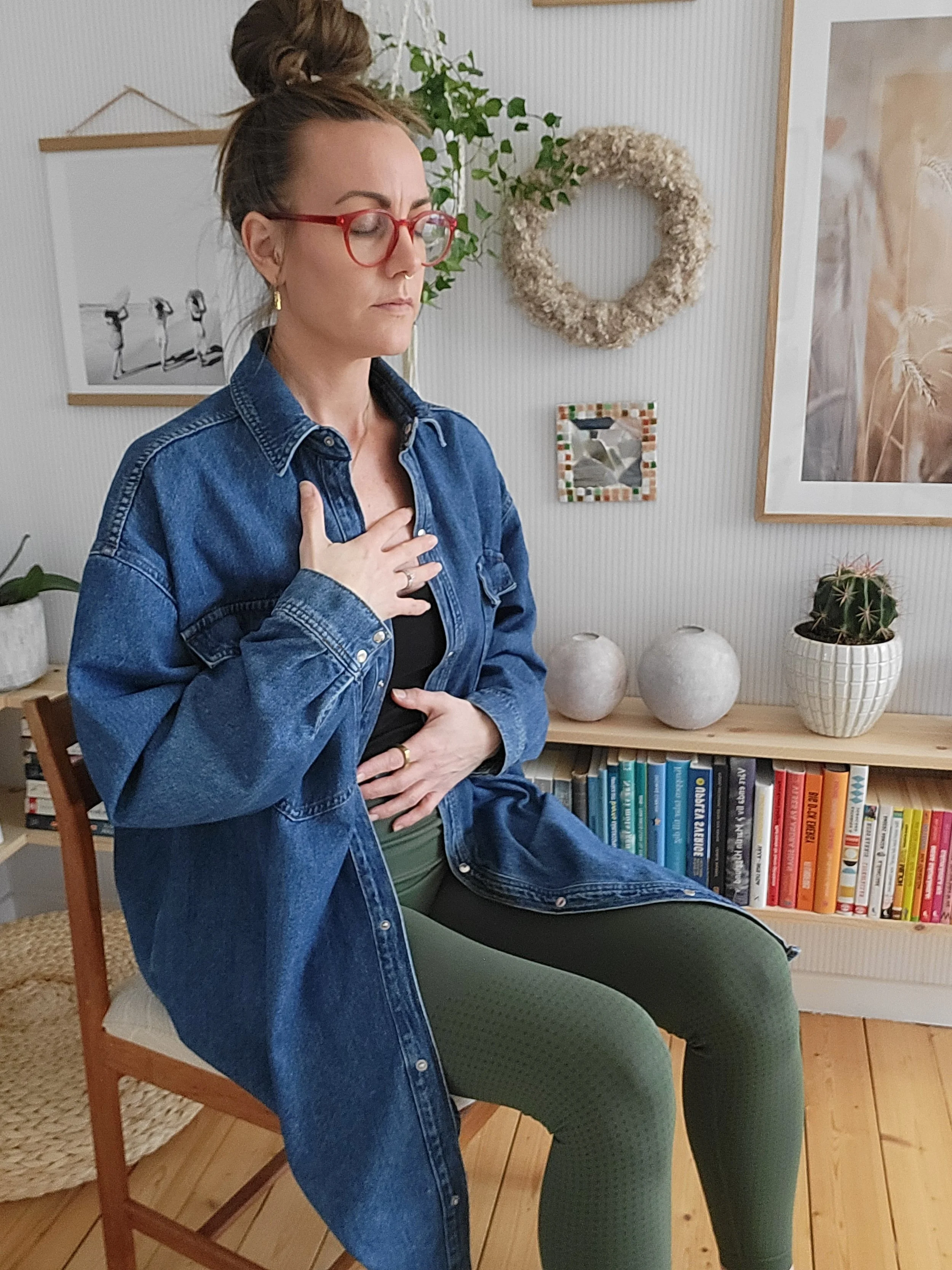 Karin sittande på stol under andningsövning i mediyoga. Fokus på andetaget och andningen är grunden i mediyoga