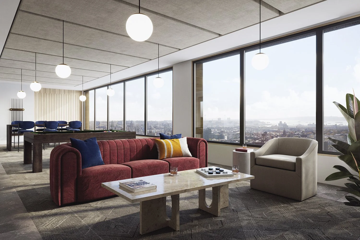 Interior of a modern high-rise apartment with large floor-to-ceiling windows offering a city view. The room has a red sofa with blue and yellow pillows, a beige armchair, a white marble coffee table with books and drinks, and a pool table in the background. The ceiling features hanging globe lights, and there is a potted plant in the corner.