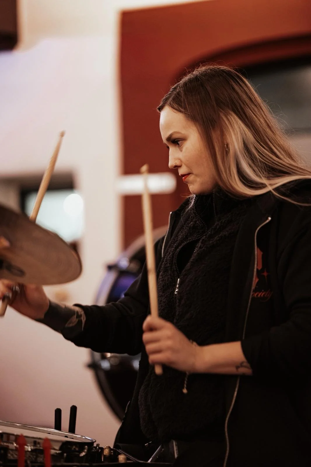 Junge Frau spielt Schlagzeug in einem Raum
